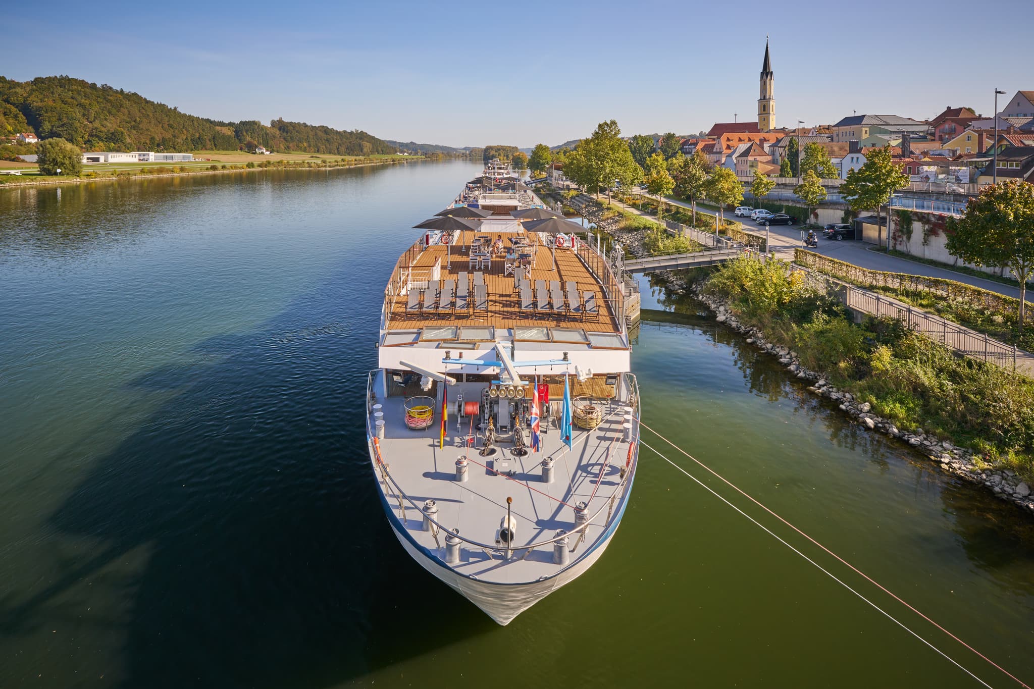 Flusskreuzfahrtschiff liegt am Donau Hafen in Vilshofen, Landkreis Passau, Niederbayern. Stadtkulisse am Flussufer im Donau-Wald, Deutschland.