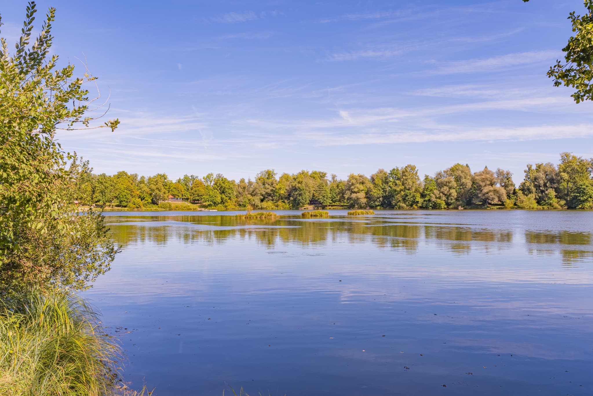 Badesee Simbach, Waldsee Lago im Sommer, Kirchdorf am Inn, Rottal-Inn, Niederbayern. Seenlandschaft mit bewaldeten Ufern im Bäderdreieck, Deutschland.