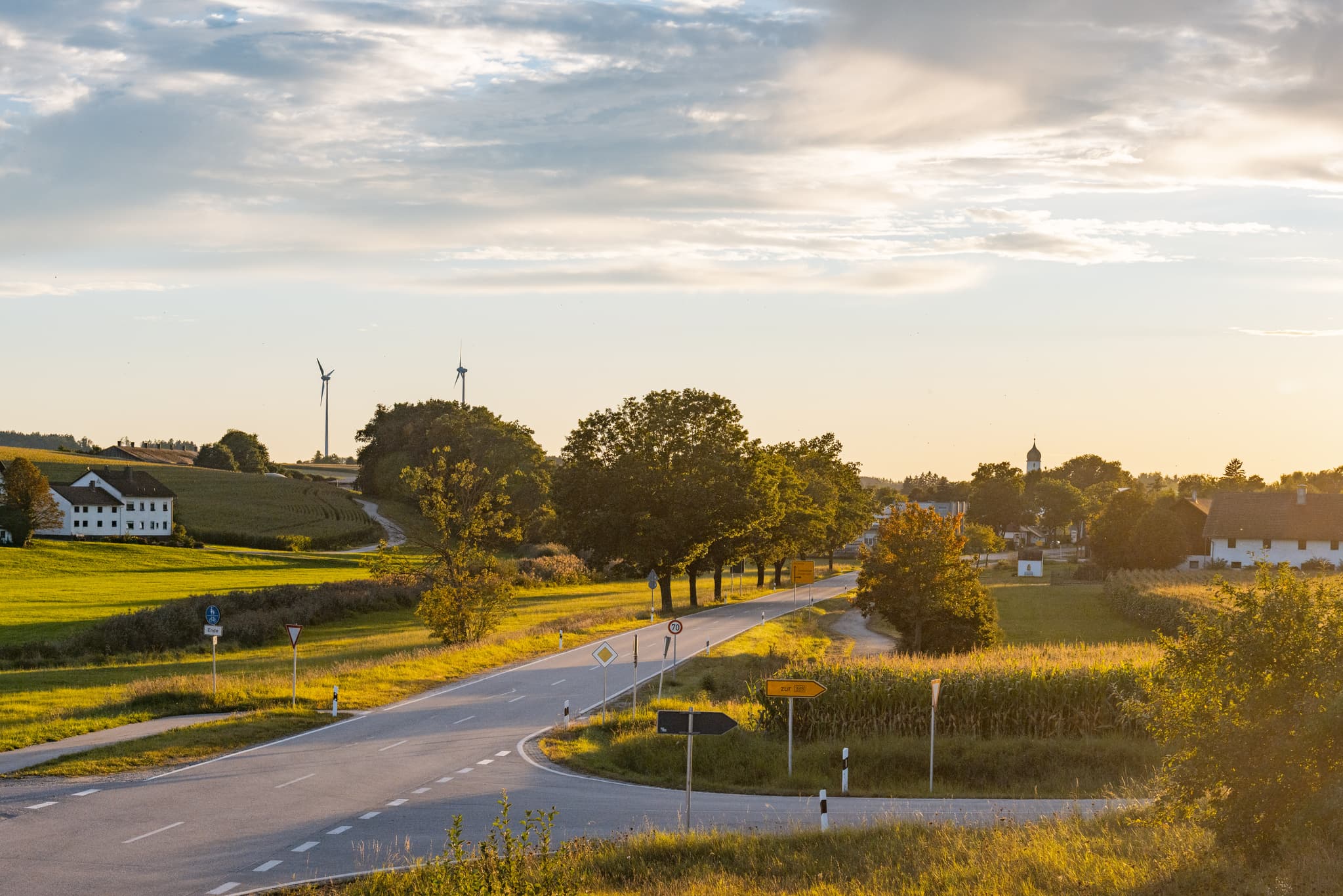 Ortsansicht Dirnaich, Gangkofen, Landkreis Rottal-Inn. Zeigt Landschaft, Felder, Straße und Windpark in der Region Holzland, Niederbayern, Deutschland.