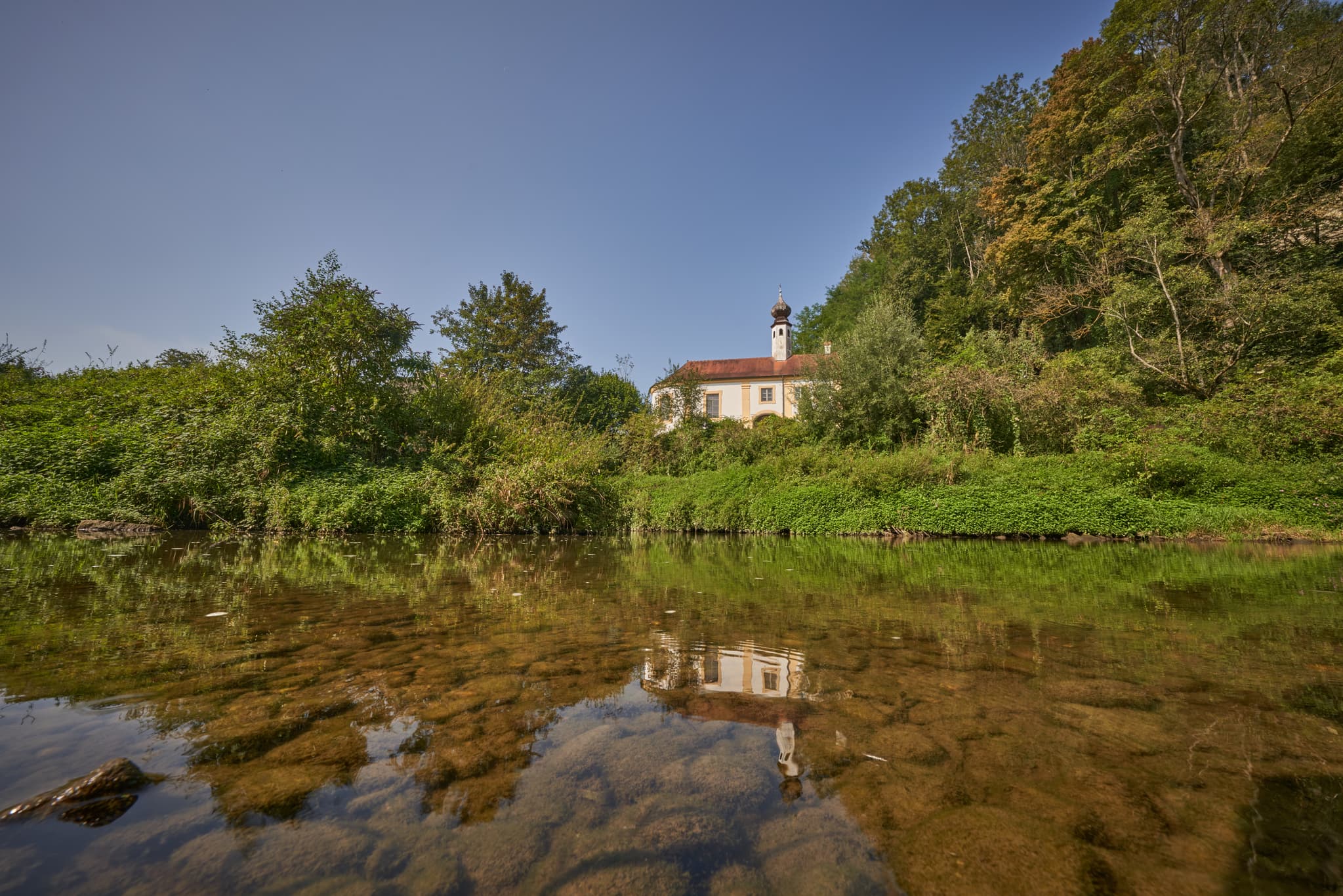 Die idyllische Engfurt Klausenkirche in Töging am Inn, Landkreis Altötting, Oberbayern, Deutschland. Ein malerisches Ensemble an der Isen, Region Inn-Salzach.