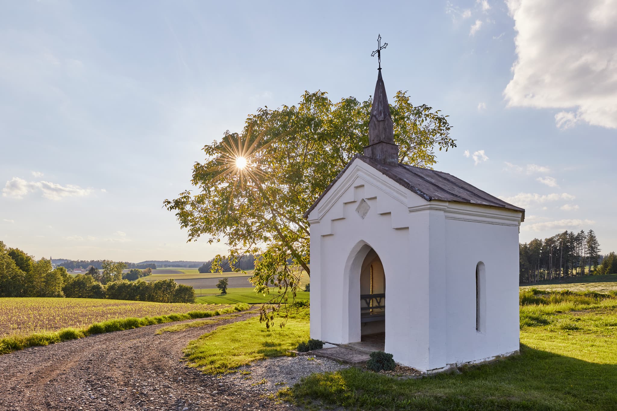 Bild einer kleinen Kapelle in Albersberg, Gemeinde Pleiskirchen, Altötting, Oberbayern, Holzland, Bayern, Deutschland. Kapelle ländlicher Umgebung mit Feldern.