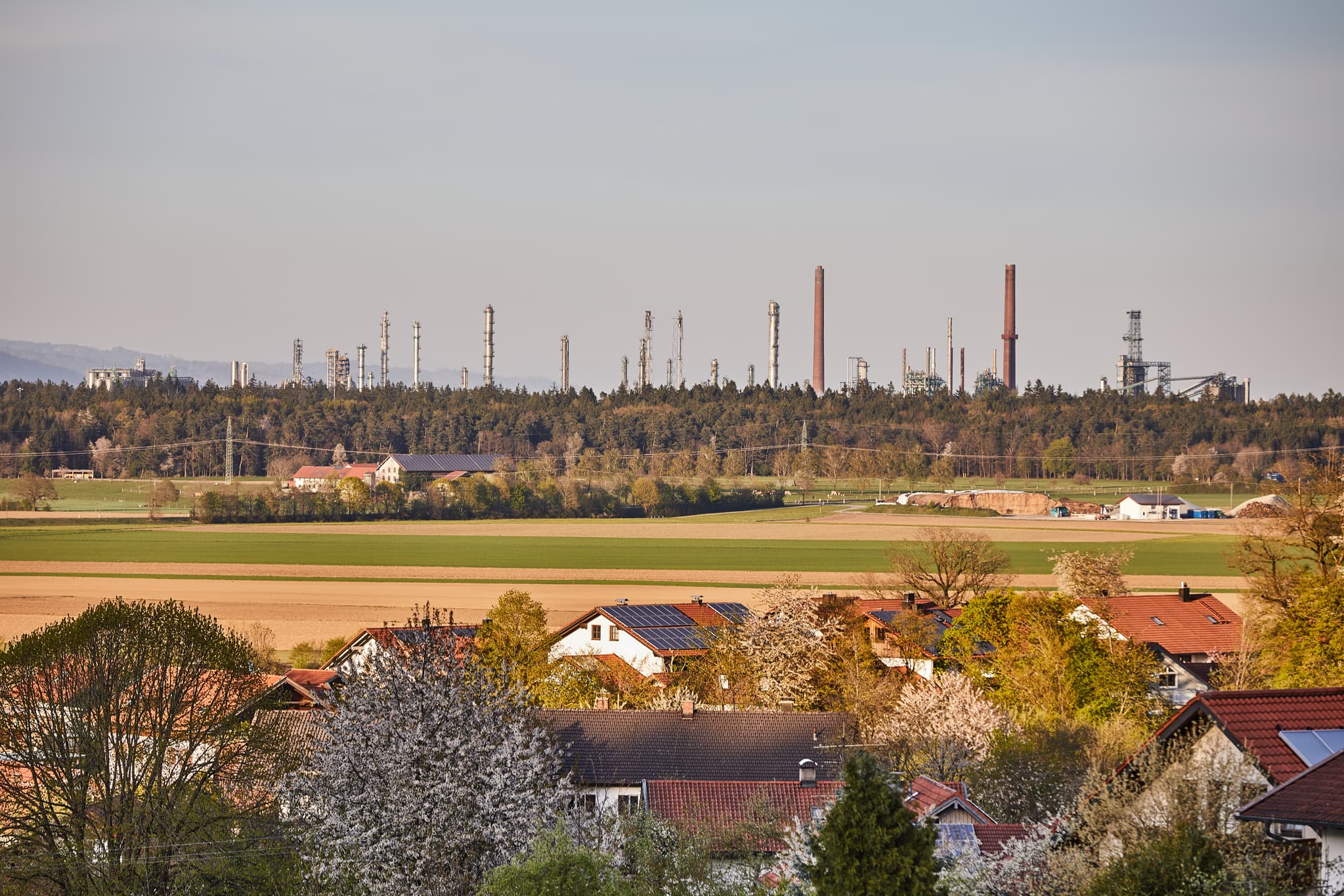 Blick vom Hörndlweg in Mehring, Altötting, Oberbayern, Deutschland. Landschaft mit Feldern, Wohngebäuden, Industrie Borealis OMV in Inn-Salzach.