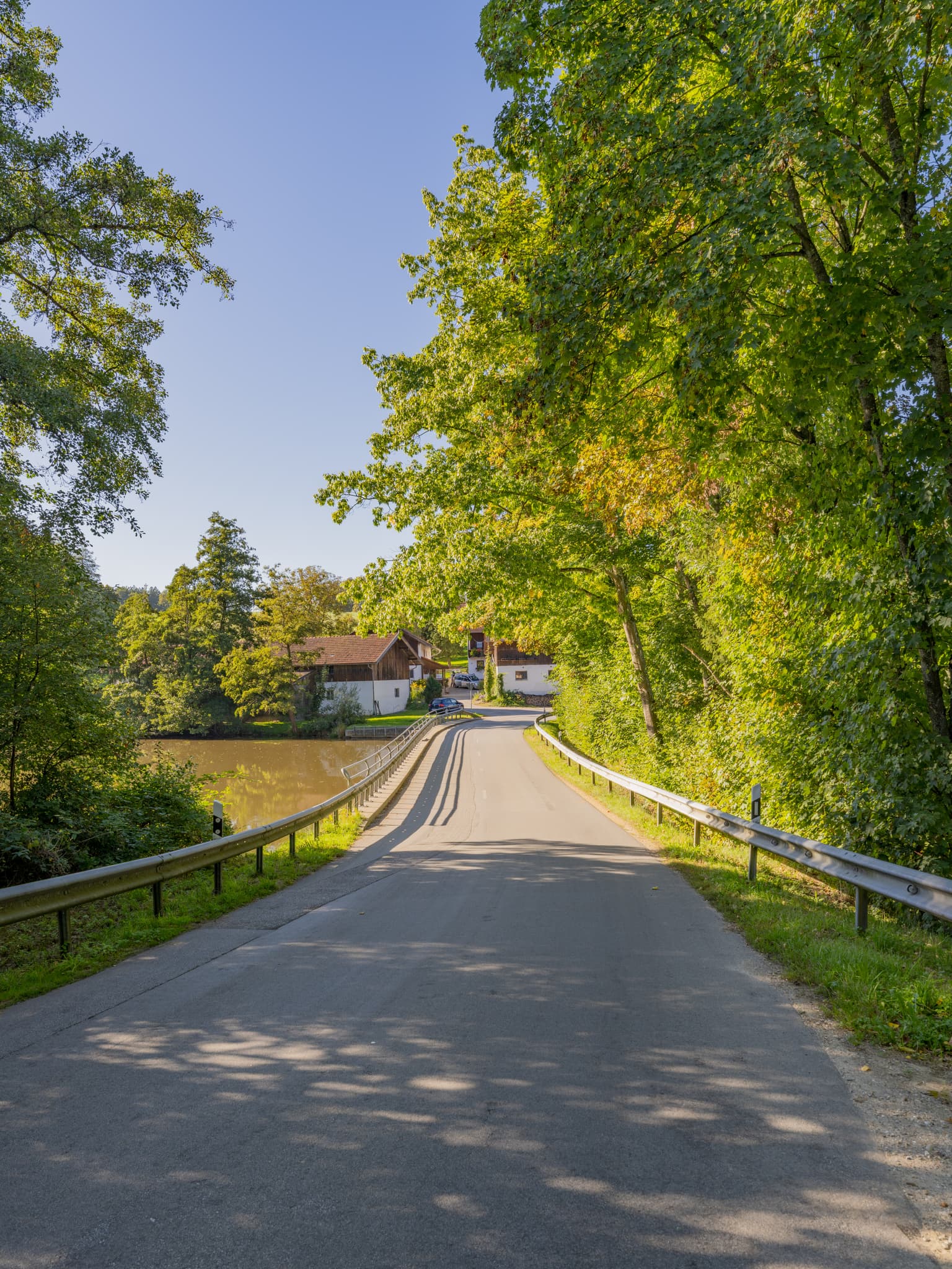 Weiher vor Baumgarten in Dietersburg, Rottal-Inn, Niederbayern, Deutschland. Ländliche Ansicht mit Gewässer, Bäumen, Häusern. Holzland am Peterskirchener Bach.