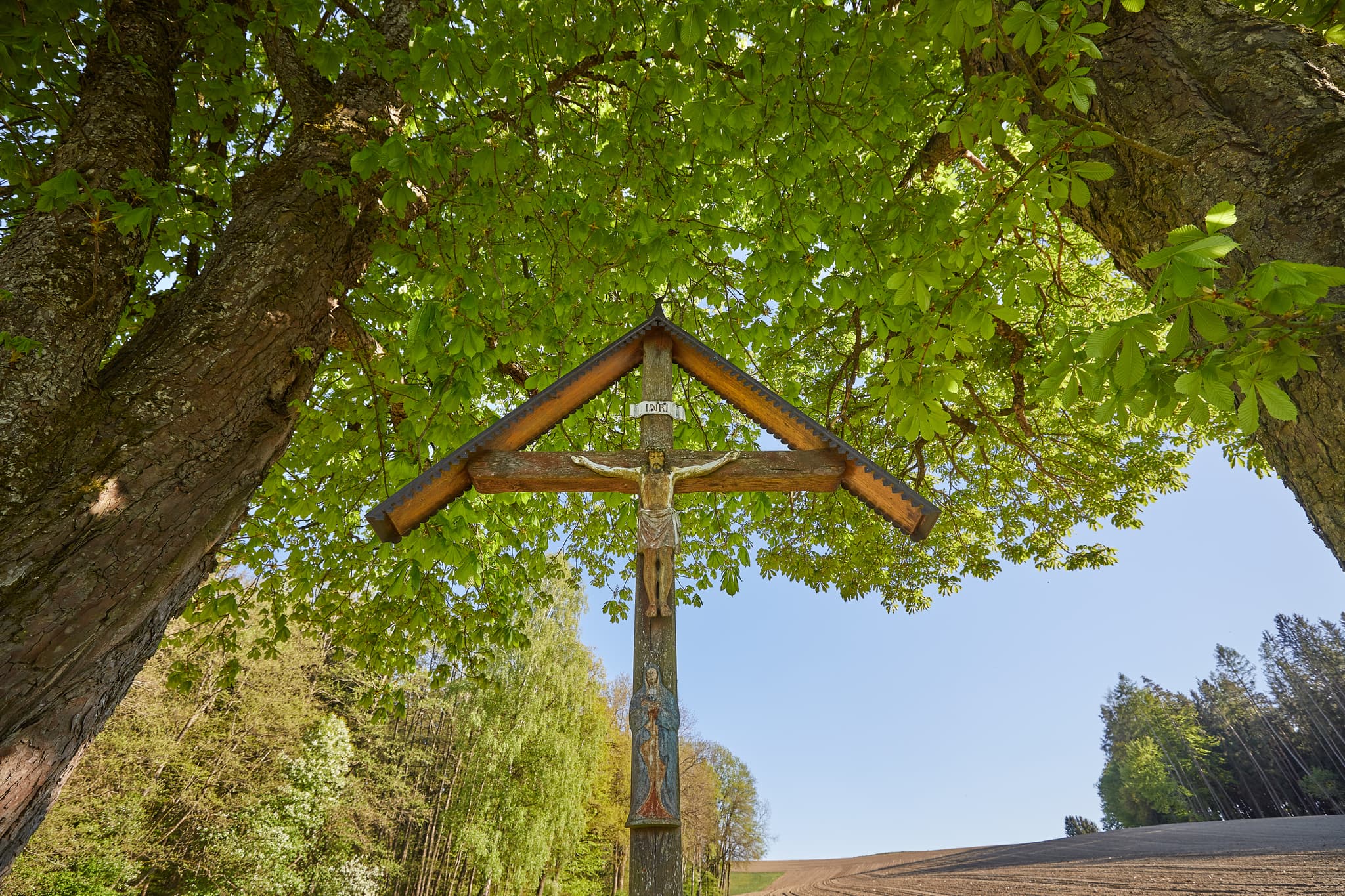 Feldkreuz in Sigrün, Pleiskirchen, Landkreis Altötting, Oberbayern, Inn-Salzach, Bayern, Deutschland. Holzkreuz inmitten einer ländlichen Landschaft.