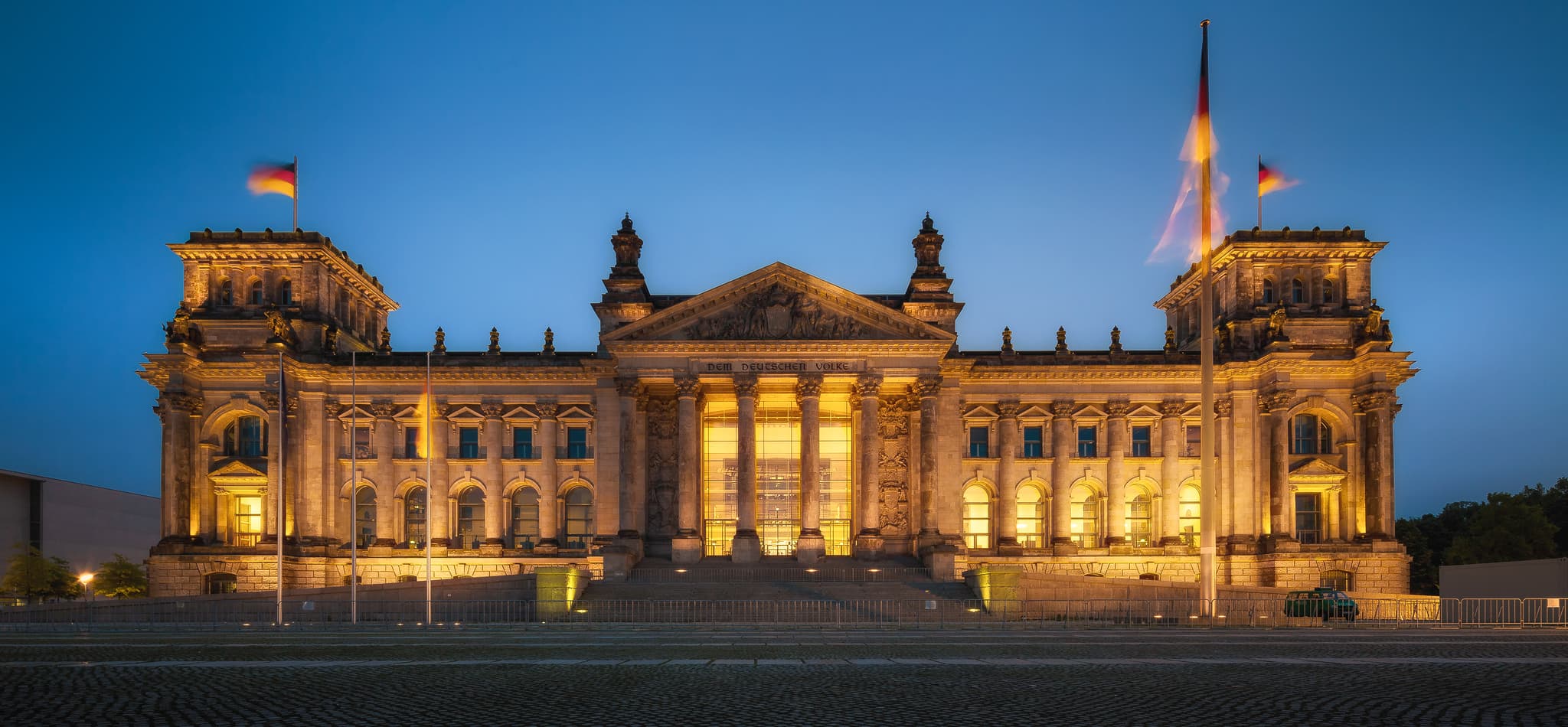 Das historische Reichstagsgebäude in Berlin präsentiert sich abendlich in voller Beleuchtung. Dieses imposante Bauwerk ist ein markantes Wahrzeichen der Stadt.