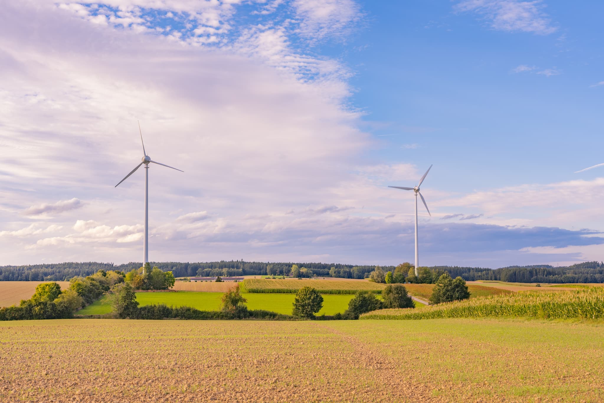 Zwei Windräder des Windparks Dirnaich prägen die Landschaft nahe Gangkofen im Landkreis Rottal-Inn, Niederbayern. Felder und Hügel im Holzland, Deutschland.