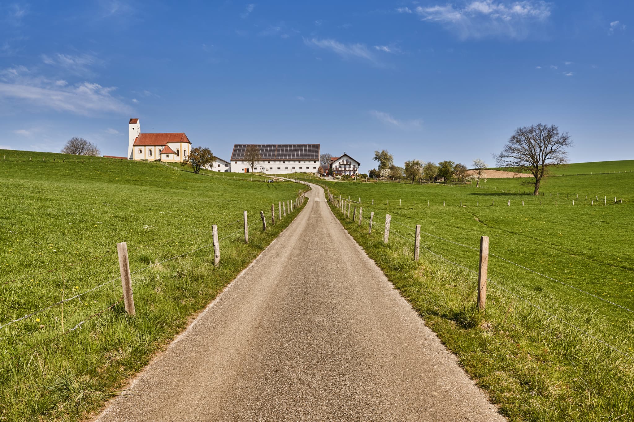 Die idyllische Kirche Sankt Pankratius in Mettenheim, Landkreis Mühldorf am Inn, Oberbayern, Inn-Salzach, Deutschland, eingebettet in malerische Landschaft.