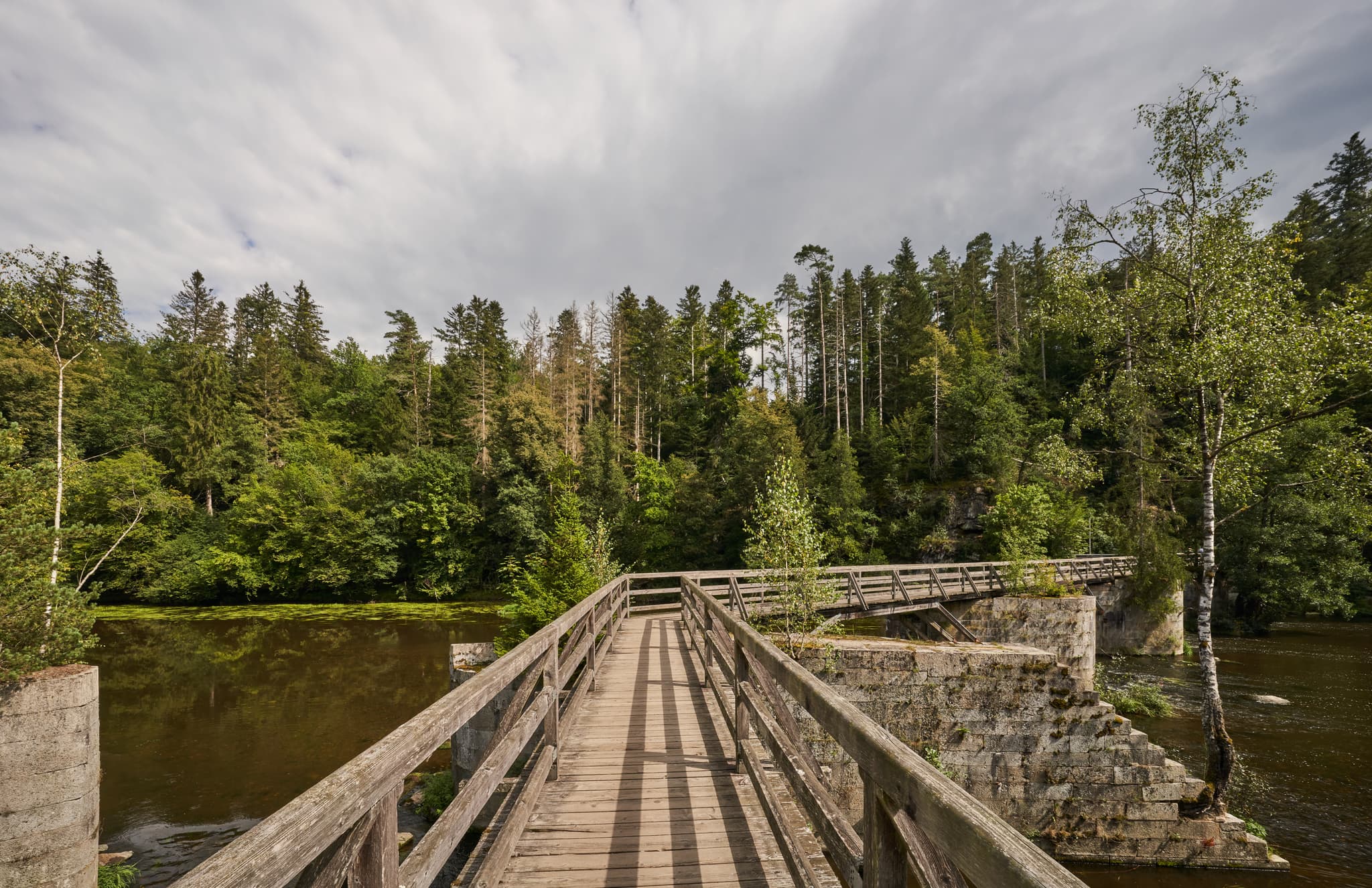 Holzbrücke über die Ilz an der Triftsperre bei Passau in Niederbayern, Deutschland. Wunderschöne Naturlandschaft im Bayerischen Wald.