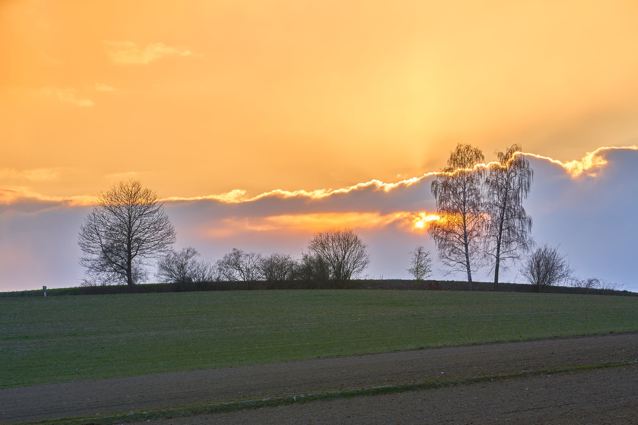 Naturlandschaft bei Sonnenuntergang in Obereck, Gemeinde Erlbach, Landkreis Altötting, Oberbayern, Deutschland. Sanfte Hügel der Region Inn-Salzach.