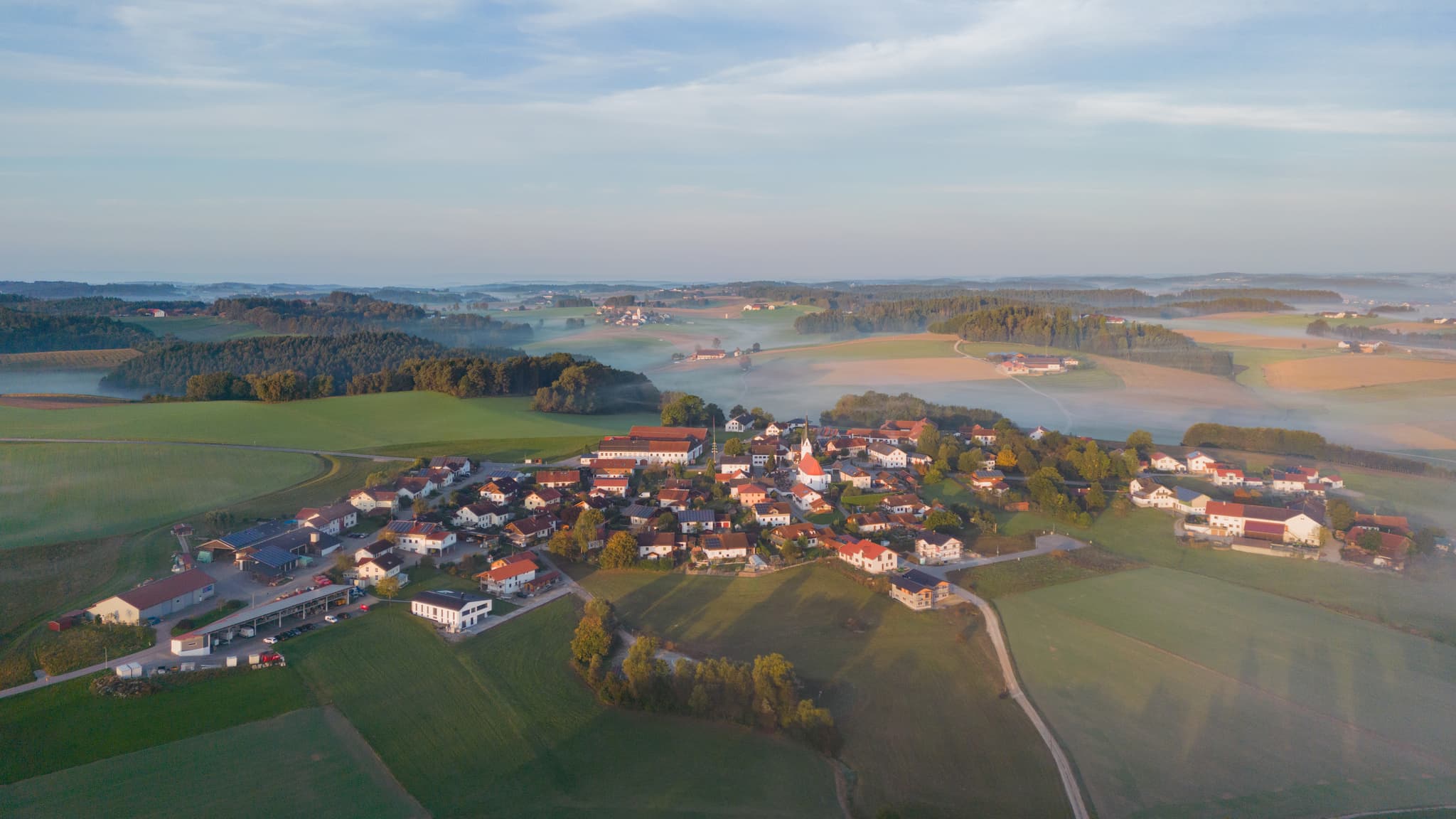 Arbing, Reischach, Holzland, Altötting, Oberbayern, Deutschland. Luftbild der weiten Landschaft bei Herbstanfang mit klarer Sicht auf das Dorf und Umgebung.