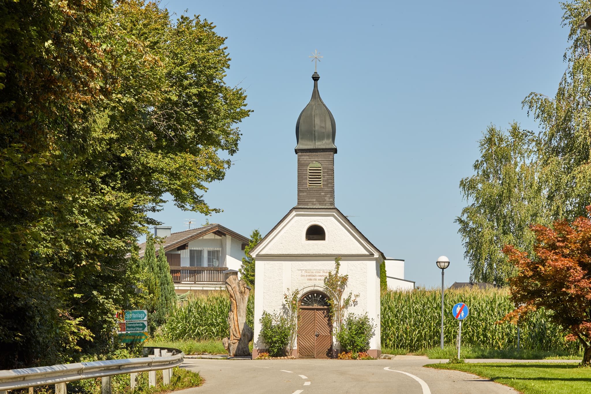Kapelle in St. Radegund, Oberösterreich, im ländlichen Innviertel. Das Gotteshaus steht umgeben von Bäumen und Maisfeldern im Bezirk Braunau am Inn, Österreich.