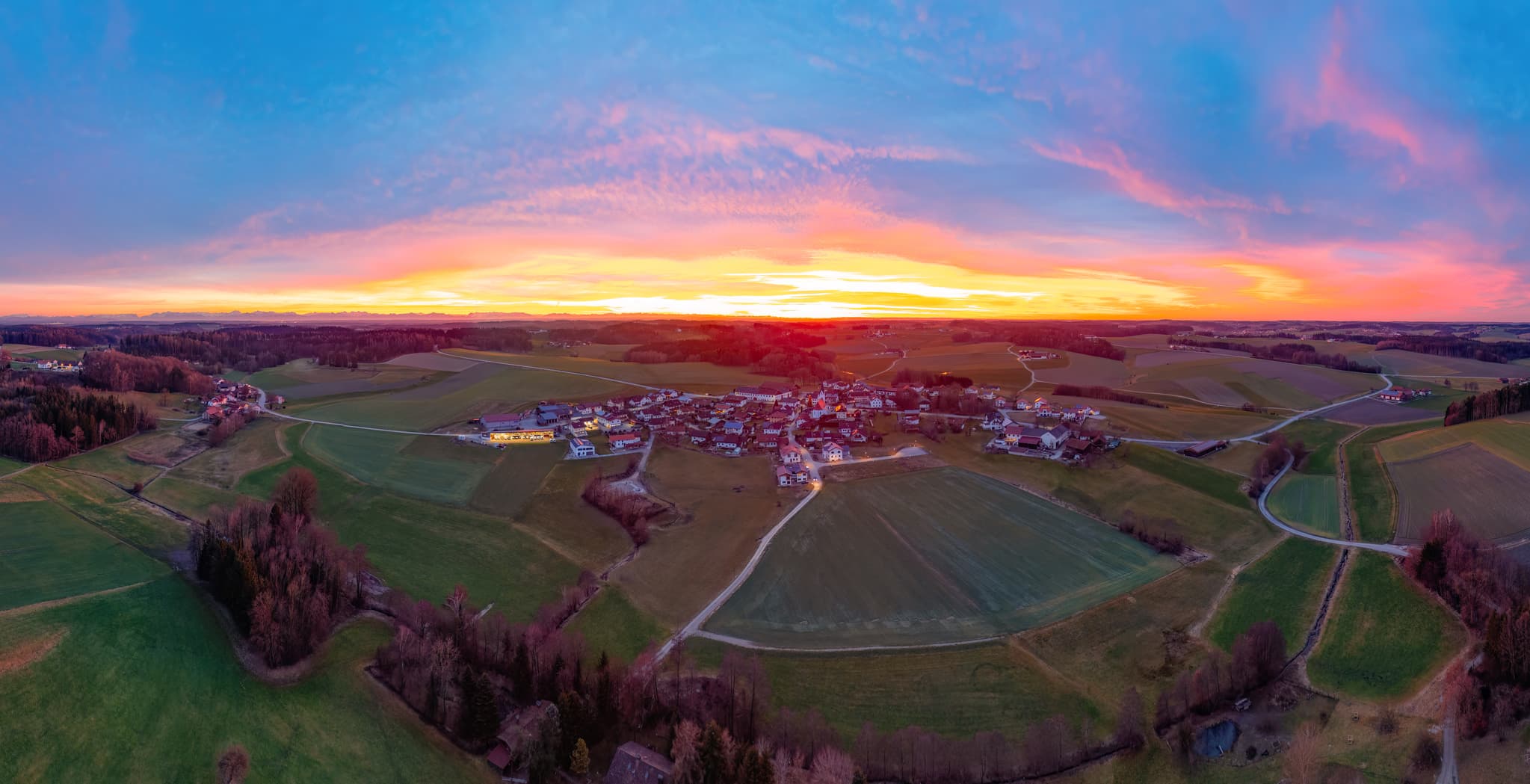 Sonnenuntergang über Arbing, Ortsteil von Reischach, Landkreis Altötting, Oberbayern. Die ländliche Region erstrahlt im warmen Dämmerlicht.