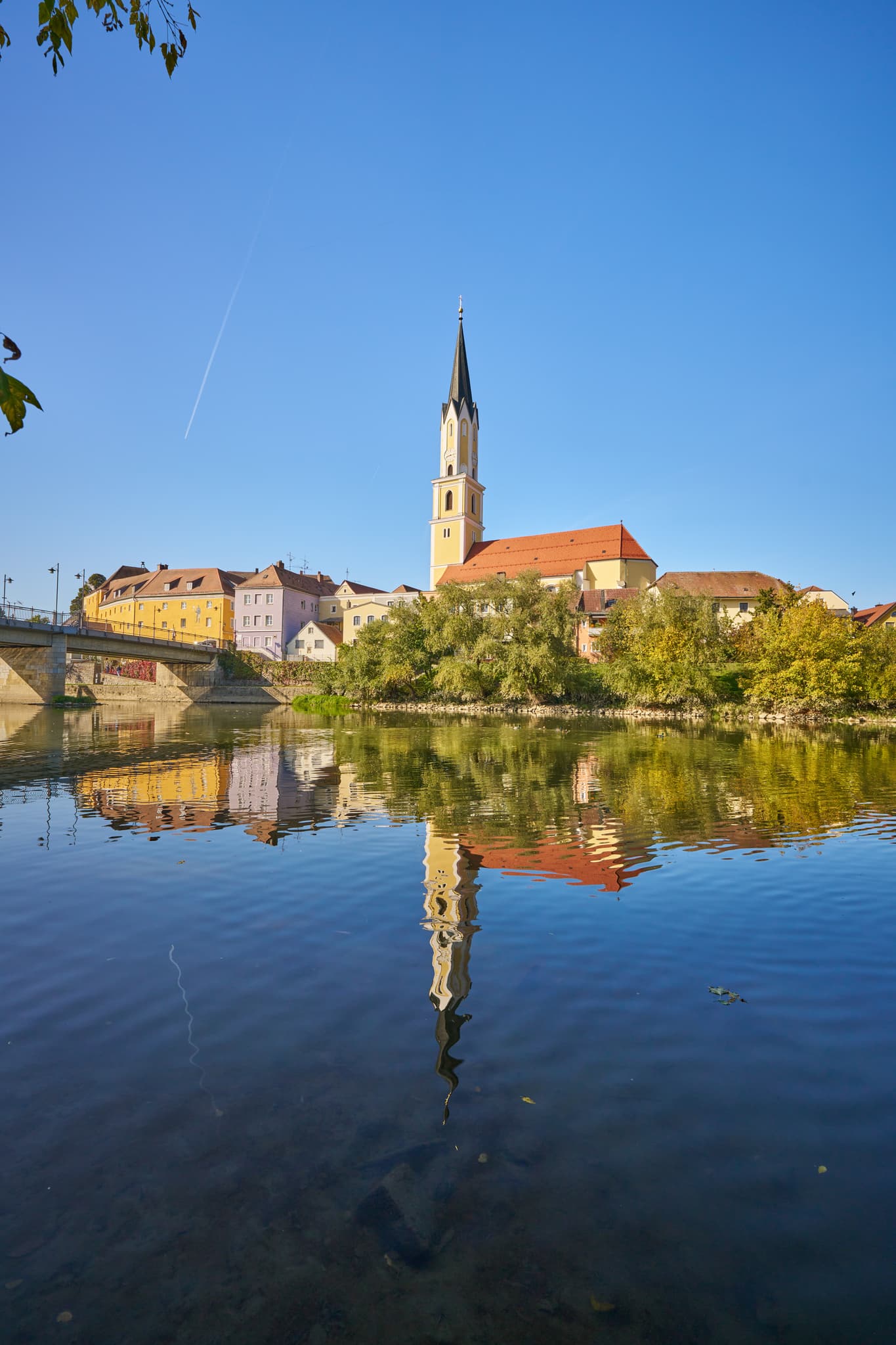 Stadtansicht von Vilshofen an der Vils im Landkreis Passau, Niederbayern. Stadt am Fluss mit Kirche, spiegelt sich im Wasser. Region Donau-Wald, Deutschland.
