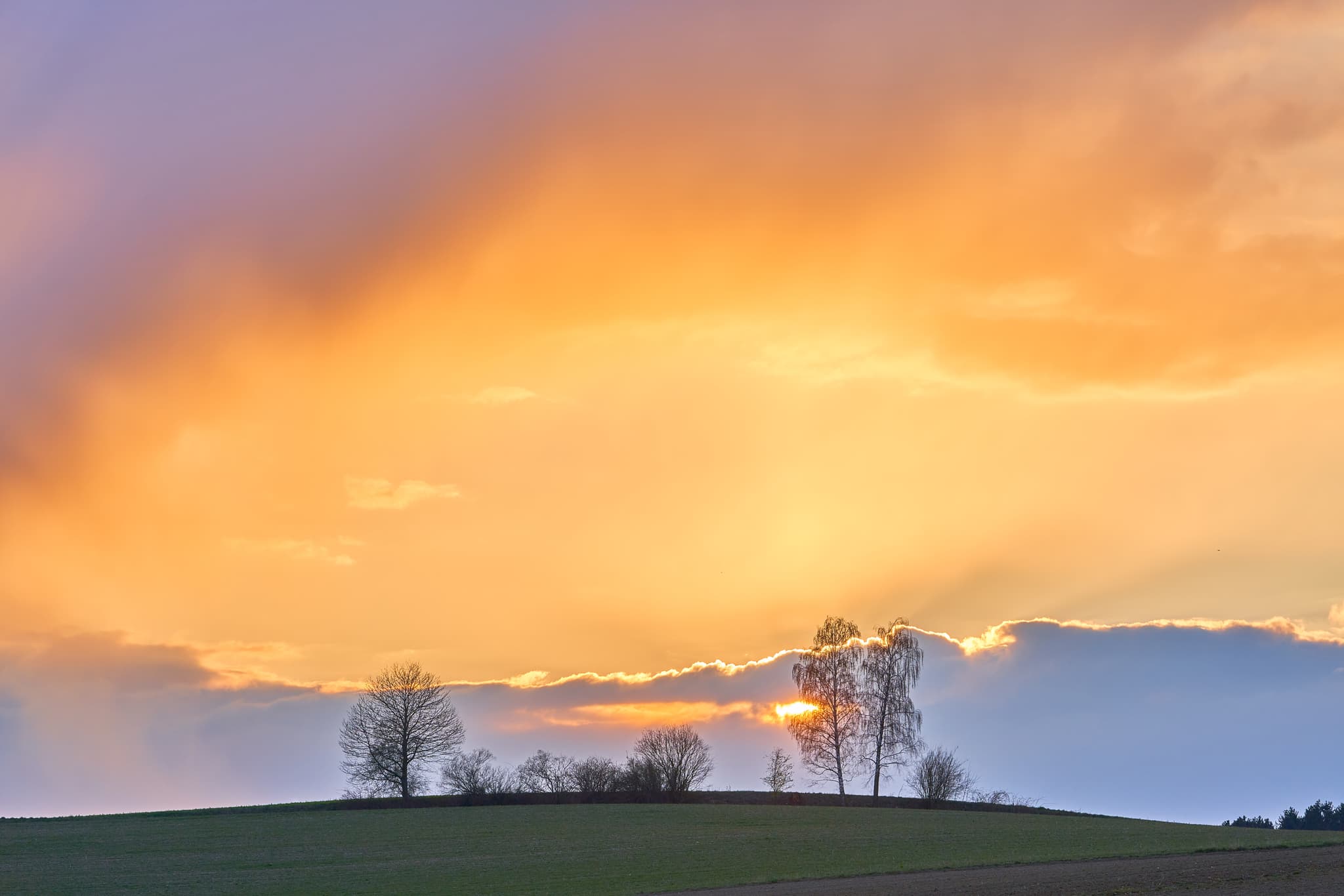 Naturlandschaft bei Sonnenuntergang in Obereck, Gemeinde Erlbach, Landkreis Altötting, Oberbayern, Deutschland. Sanfte Hügel der Region Inn-Salzach.