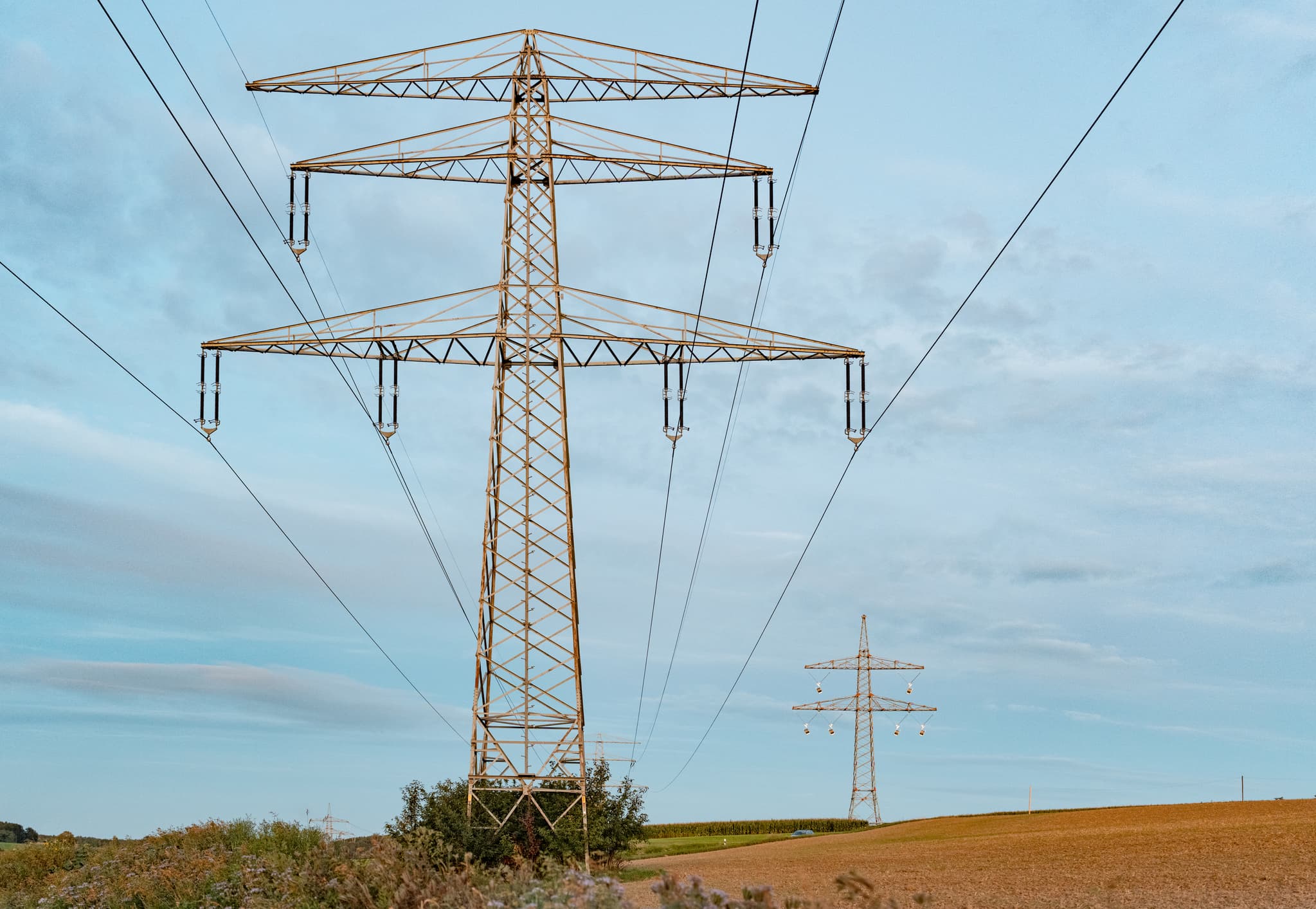 Zwei Strommasten prägen ländliche Landschaft nahe Frauenhaselbach, Neumarkt St. Veit. Landkreis Mühldorf am Inn, Oberbayern, Inn-Salzach, Deutschland.