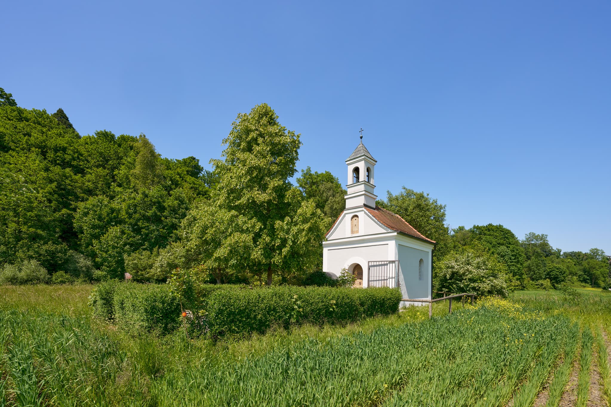 Kronwidl Kapelle in Ecksberg Altmühldorf, Mühldorf am Inn, Oberbayern. Kapelle in der Inn-Salzach Region, Deutschland, umgeben von grünen Feldern und Bäumen.