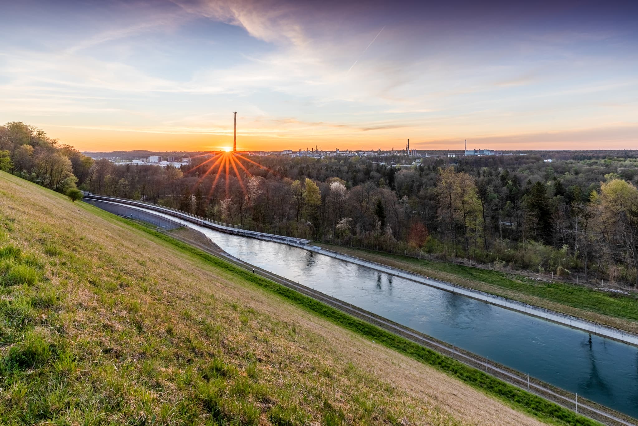 Alzkanal und Werk Gendorf, Burgkirchen, Altötting, Oberbayern, Inn-Salzach, Deutschland. Die Abendsonne beleuchtet die Industrielandschaft und den Kanal.