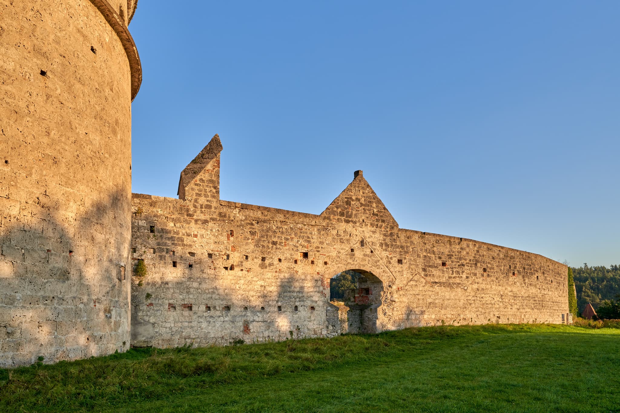Alte Burgmauer und Rundturm am Wöhrsee in Burghausen, Landkreis Altötting, Oberbayern. Die historische Anlage liegt in der Region Inn-Salzach, Deutschland.