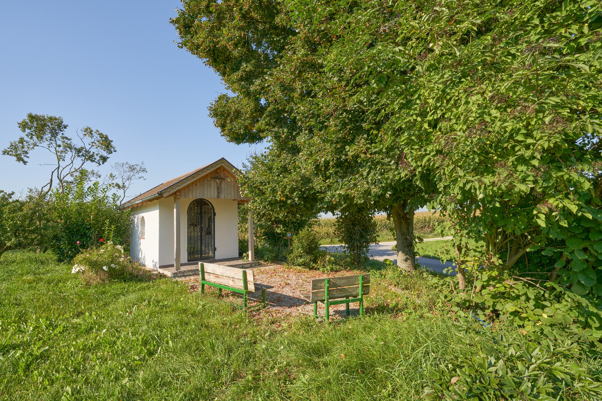 Kapelle in Reit, ländliche Abzweigung mit Feldwegen, umgeben von grünen Wiesen und Äckern in Kastl, Landkreis Altötting, Oberbayern.