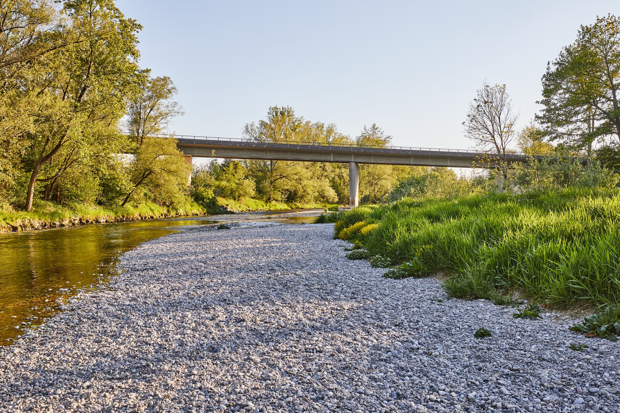 Blick auf die Alz Brücke in Emmerting, Landkreis Altötting, Oberbayern. Flusslandschaft im Inn-Salzach-Gebiet in Deutschland mit Kiesbank und grünen Ufern.