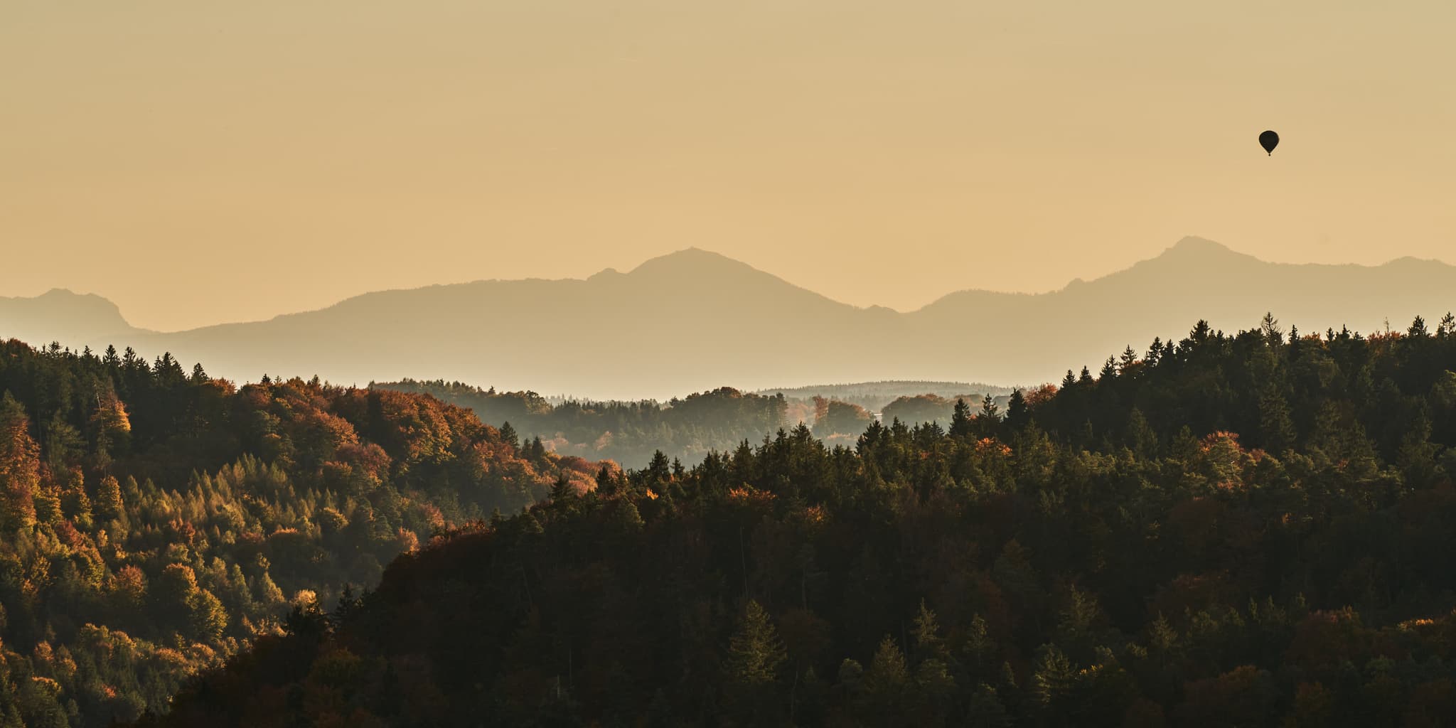 Heißluftballon über herbstlichen Hügeln nahe Salzachblick Pirach, Burgkirchen, Altötting, Oberbayern. Inn-Salzach Region. Wälder mit Dunst, Herbstfarben.