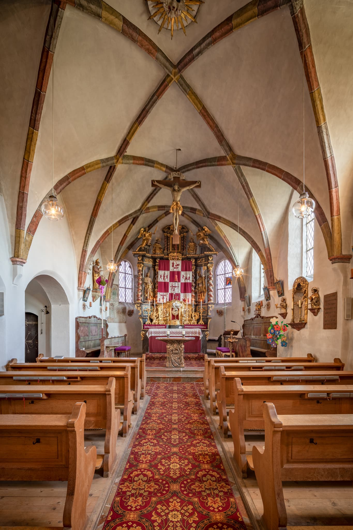 Innenansicht der Pfarrkirche Mariä Himmelfahrt in Perach, Landkreis Altötting, Oberbayern, Region Inn-Salzach, Deutschland. Altar, Kirchenschiff und Gewölbe.