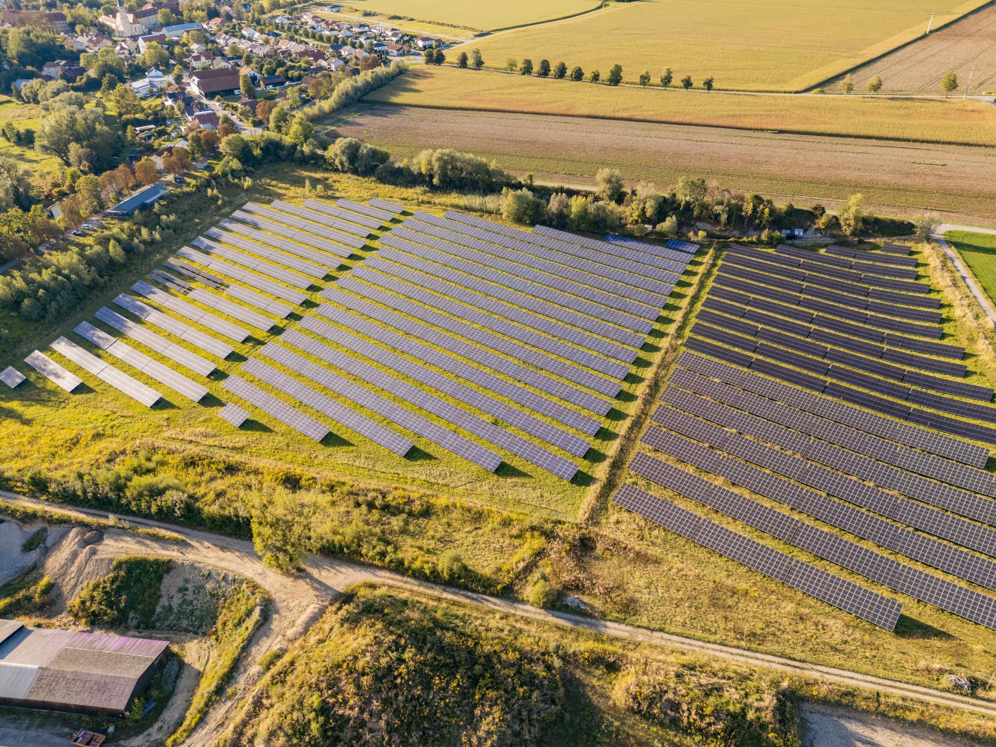 Photovoltaik-Freiflächenanlage bei Ering am Inn, Rottal-Inn, Niederbayern, Deutschland. Die Anlage in der Region Bäderdreieck, umgeben von Feldern und Siedlung.
