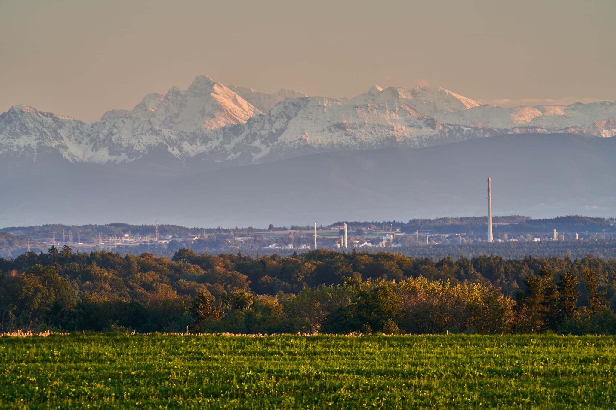 Blick von Hoheneck Aussicht in Reischach, Altötting, Oberbayern. Zeigt Felder, Wald, Industrieanlagen und schneebedeckte Alpen. Inn-Salzach, Deutschland.