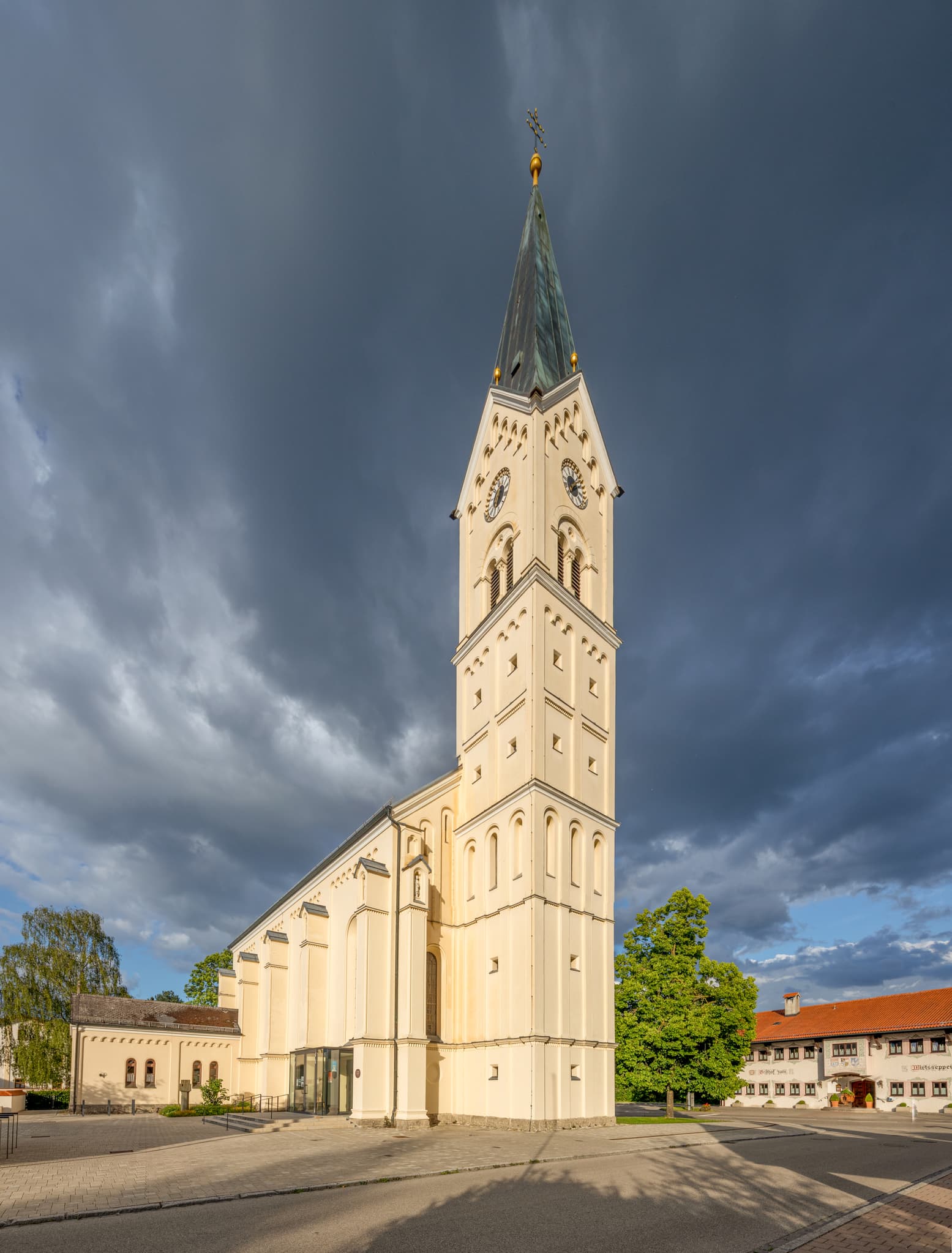 Pfarrkirche St. Nikolaus in Garching an der Alz, Landkreis Altötting, Oberbayern, Deutschland. Kirchengebäude in der Region Inn-Salzach unter wolkigem Himmel.