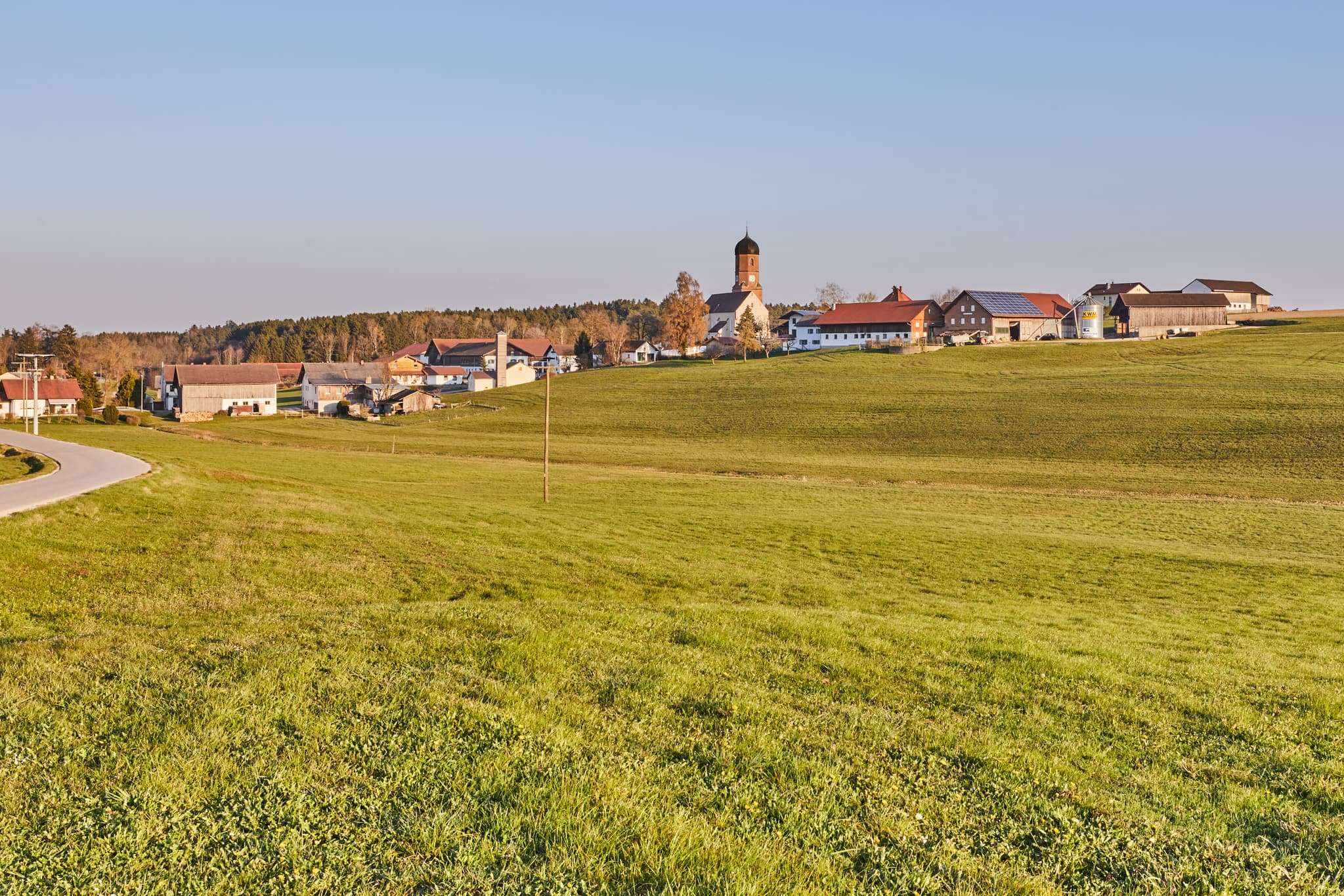 Martinskirchen, Wurmannsquick, Landkreis Rottal-Inn, Niederbayern. Die ländliche Umgebung des Holzlands zeigt weite Felder und einen kleinen Ort mit Kirche.