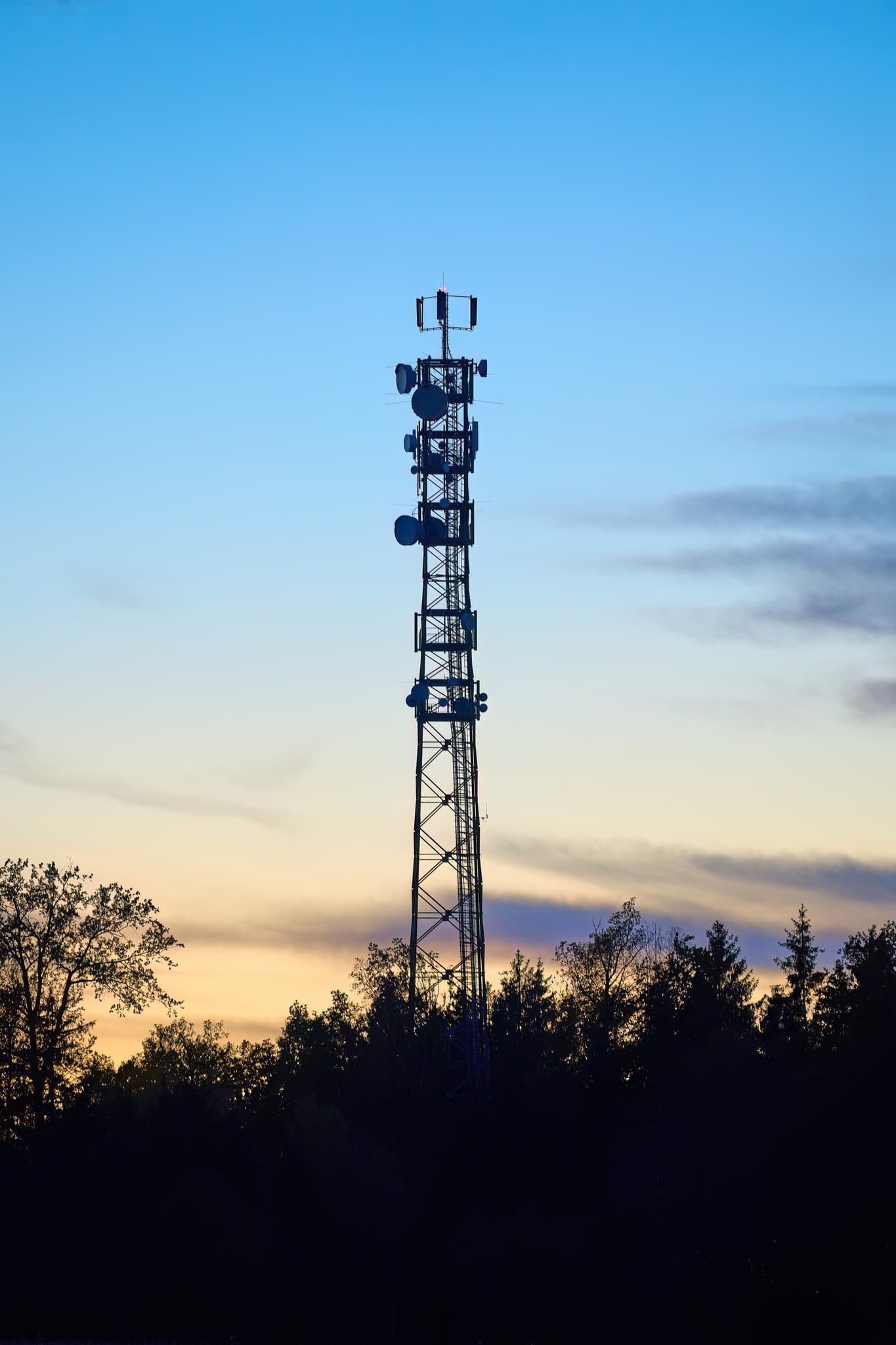 Funkturm im Abendhimmel in Rottenstuben, Hebertsfelden, Rottal-Inn, Niederbayern. Silhouette von Turm und Bäumen prägen die Landschaft im Holzland, Deutschland.