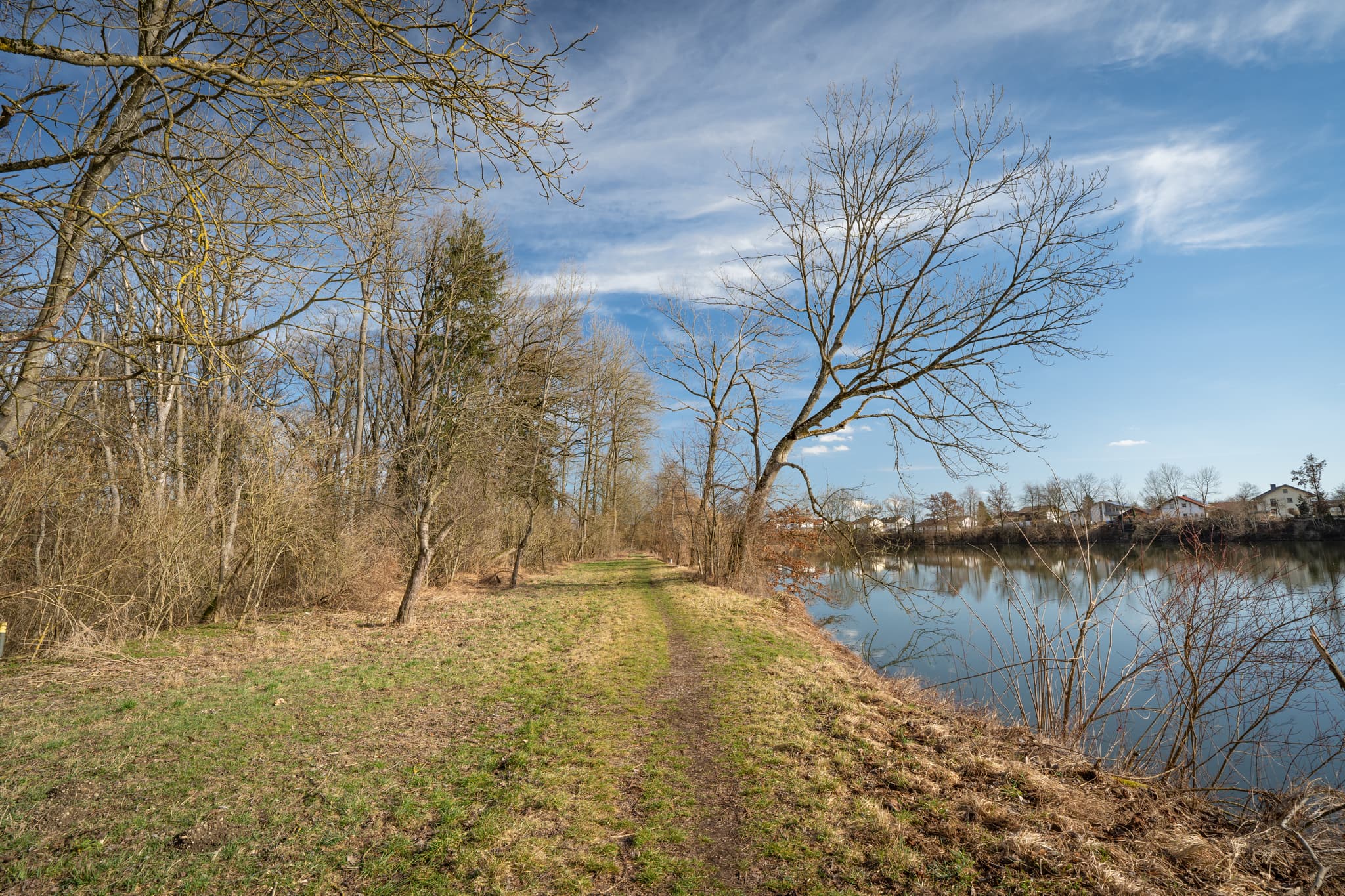Landschaftsbild vom Isen-Stausee bei Winhöring im Landkreis Altötting, Oberbayern. Ein Uferweg führt entlang des Sees durch die Natur der Inn-Salzach-Region.