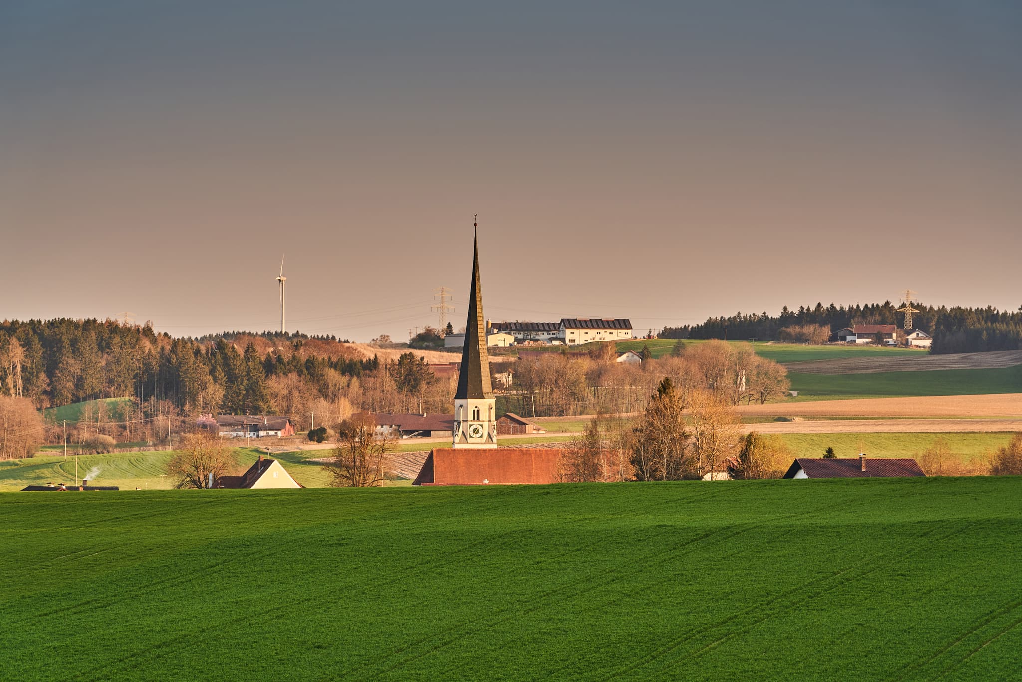 Landschaft mit Kirche inmitten grüner Felder, Hügeln und Wäldern bei Rogglfing, Wurmannsquick, Landkreis Rottal-Inn, Niederbayern, Holzland, Deutschland.