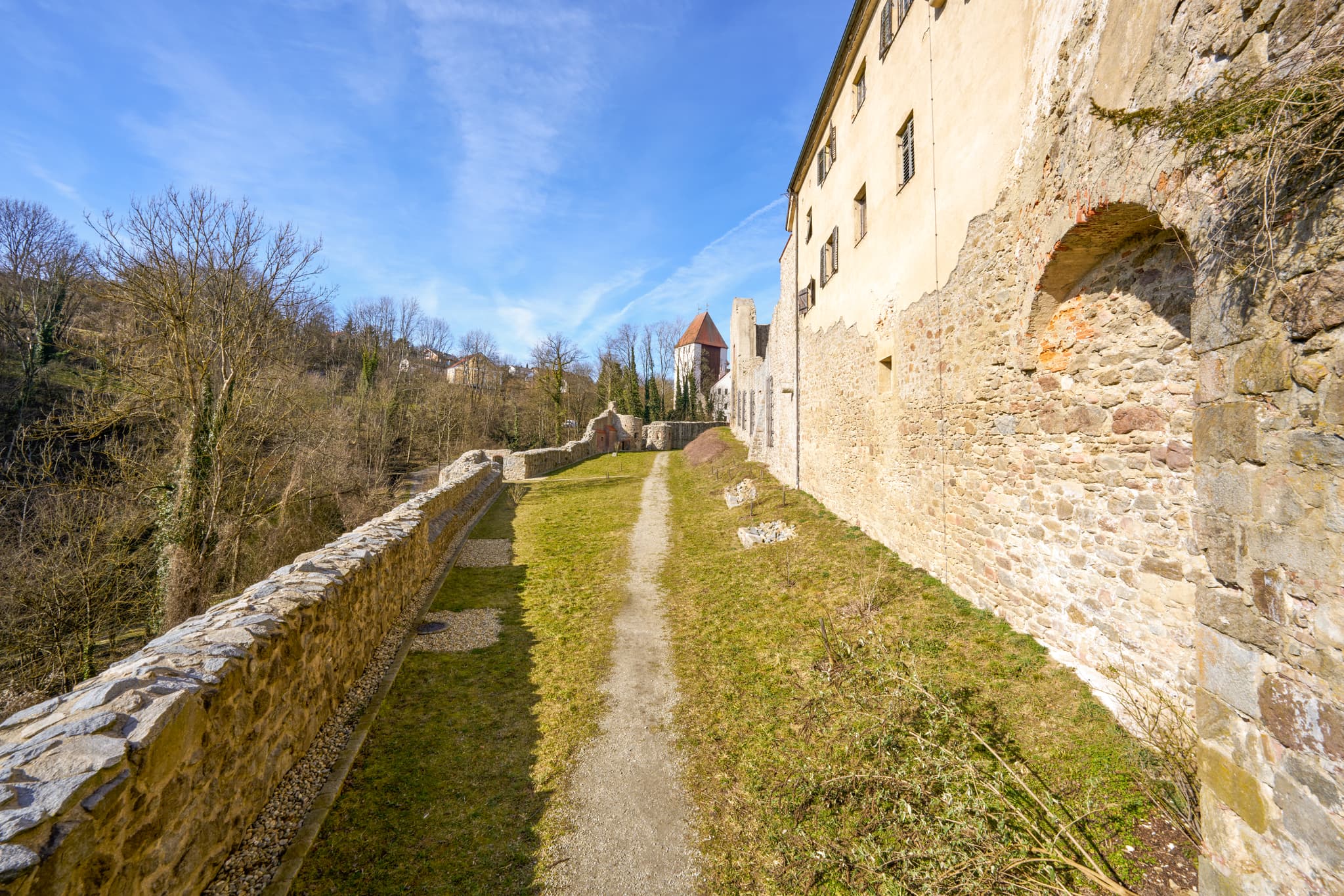 Schloss Neuburg am Inn Anlage in Niederbayern, Deutschland. Imposante Außenmauern und ein Weg prägen die Landschaft im Landkreis Passau, Region Donau-Wald.
