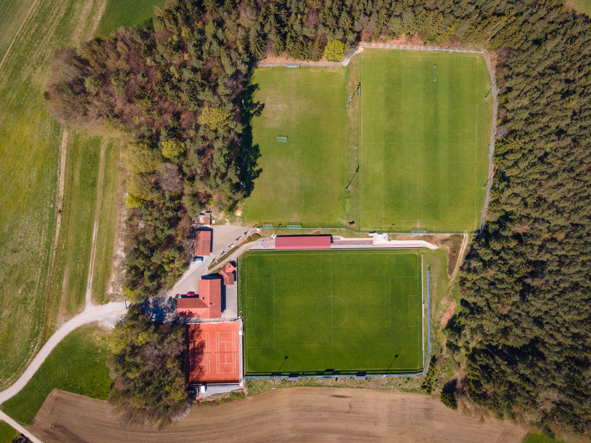Luftbild eines Sportplatzes in Erlbach, Landkreis Rottal-Inn, Niederbayern, Bayern, Deutschland. Es zeigt Fußballfelder, Tennisplatz und Gebäude.