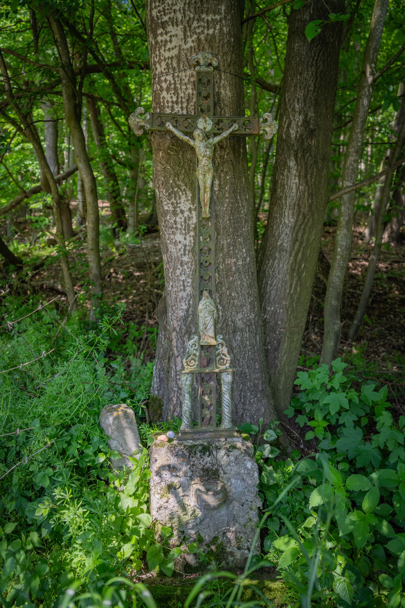 Ein verwittertes Holzkreuz steht in einem Waldstück bei Kager Indobl in der Gemeinde Reischach im oberbayerischen Landkreis Altötting, Region Inn-Salzach.