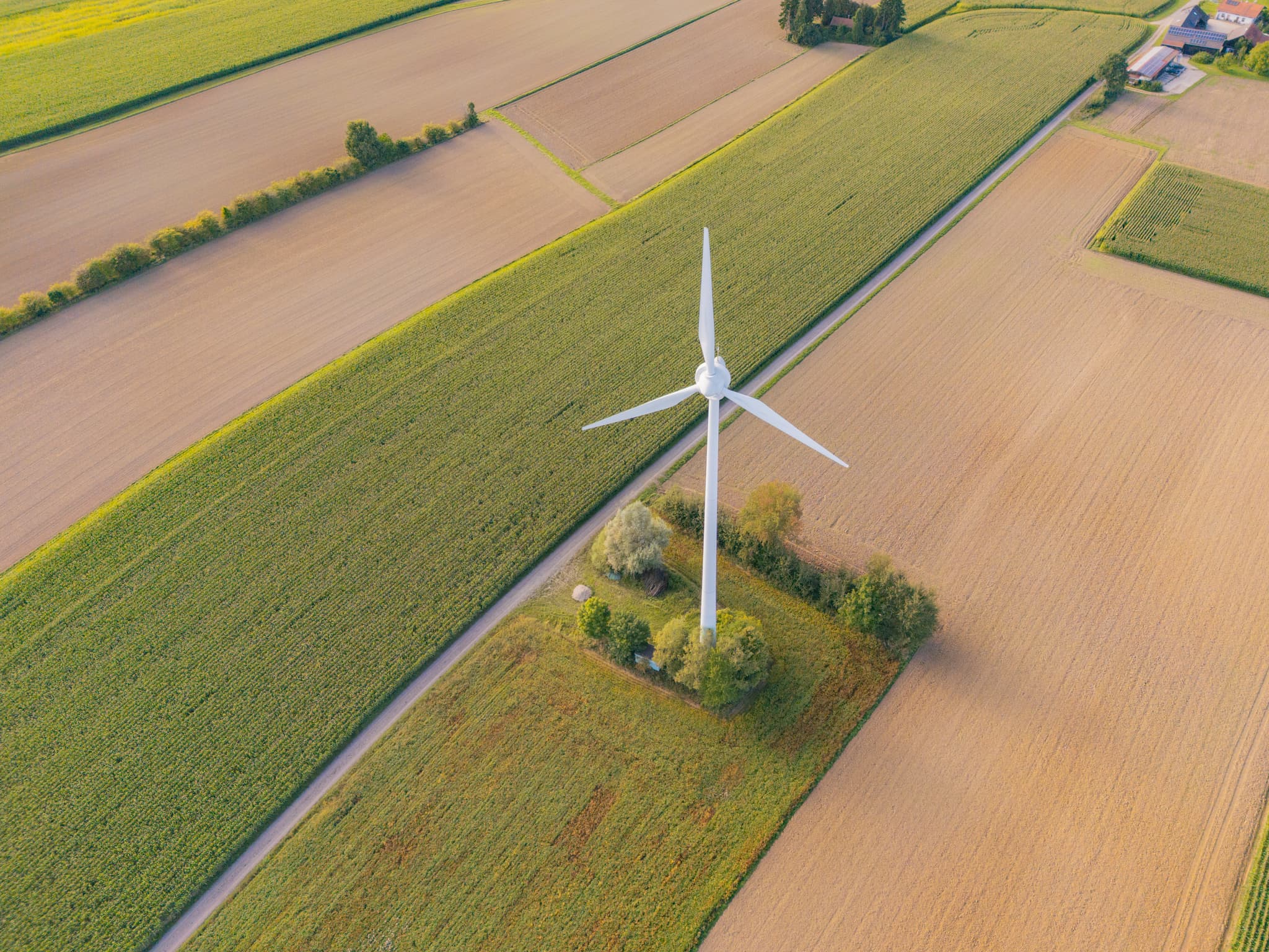 Zwei Windkraftanlagen inmitten weitläufiger Felder und grüner Landschaft bei Dirnaich, Gangkofen, im Landkreis Rottal-Inn, Niederbayern, Holzland.