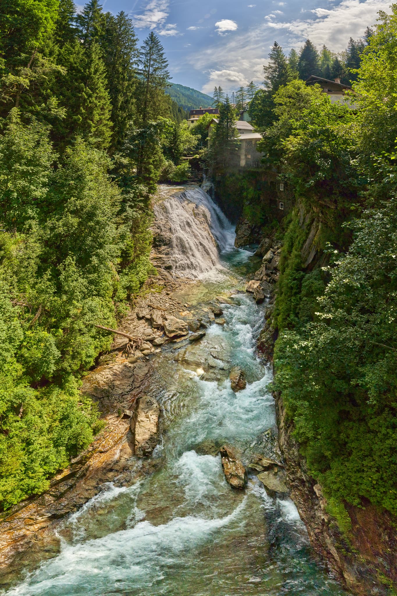 Ein beeindruckender Wasserfall und Gebirgsfluss, umgeben von grünen Wäldern, in Wasserfall oben, Bad Gastein, Pongau, Salzburg, Salzburger Land, Österreich.