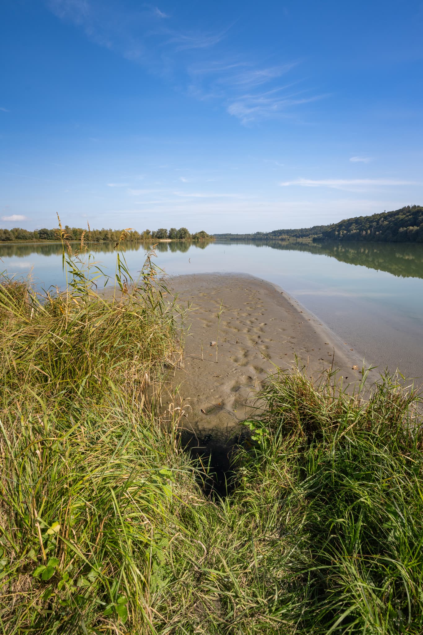 Innspitz in Haiming, Landkreis Altötting, Oberbayern, Deutschland. Die Flusslandschaft der Region Inn-Salzach mit Uferbereich und klarem Himmel.