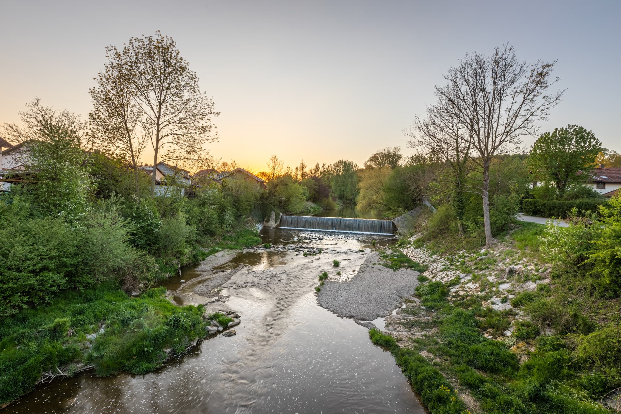 Idyllische Aufnahme der Isenbrücke in Winhöring, Landkreis Altötting, Oberbayern. Die friedliche Flusslandschaft im Inn-Salzach Gebiet bei Sonnenuntergang.