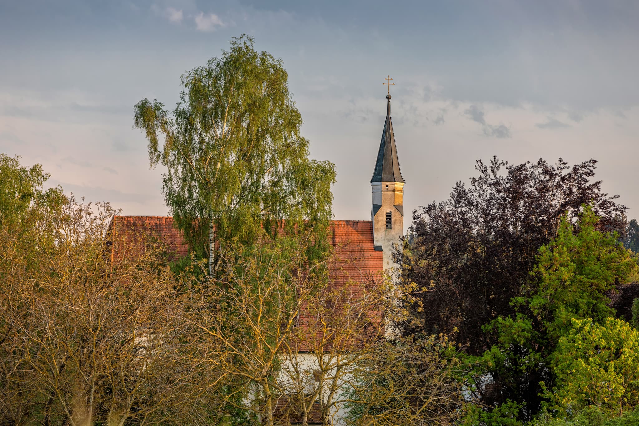 Sankt Kolomann in Kirchhaunberg, Gemeinde Reischach, Altötting, Oberbayern, Inn-Salzach, Deutschland, ist auf dem Bild zu sehen. Sie ist von Bäumen umgeben.