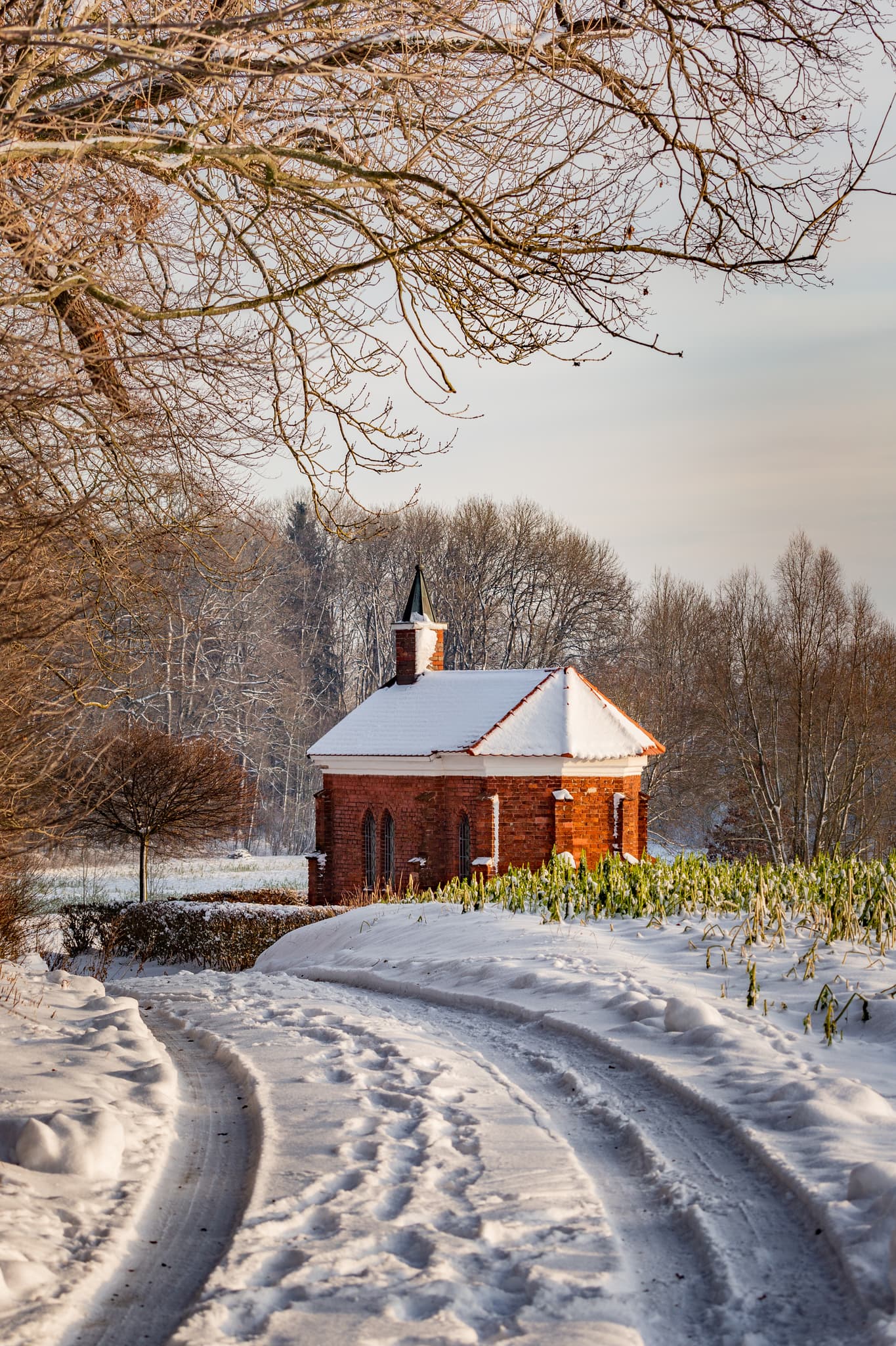 Winterliche Isen Kapelle in Winhöring, Landkreis Altötting, Oberbayern. Die Kapelle steht in der verschneiten Landschaft der Region Inn-Salzach, Deutschland.