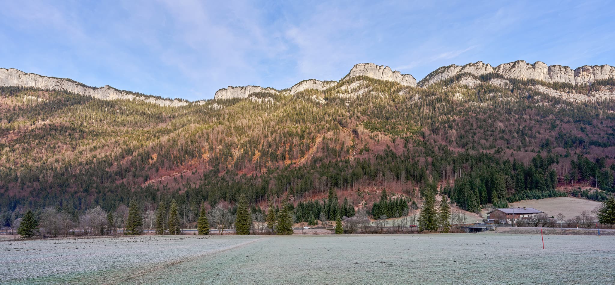 Panoramablick auf die Steinplatte bei Waidring, Kitzbühel, Tirol, Österreich. Die Landschaft der Kitzbüheler Alpen zeigt Berge, Wälder und gefrorene Wiesen.
