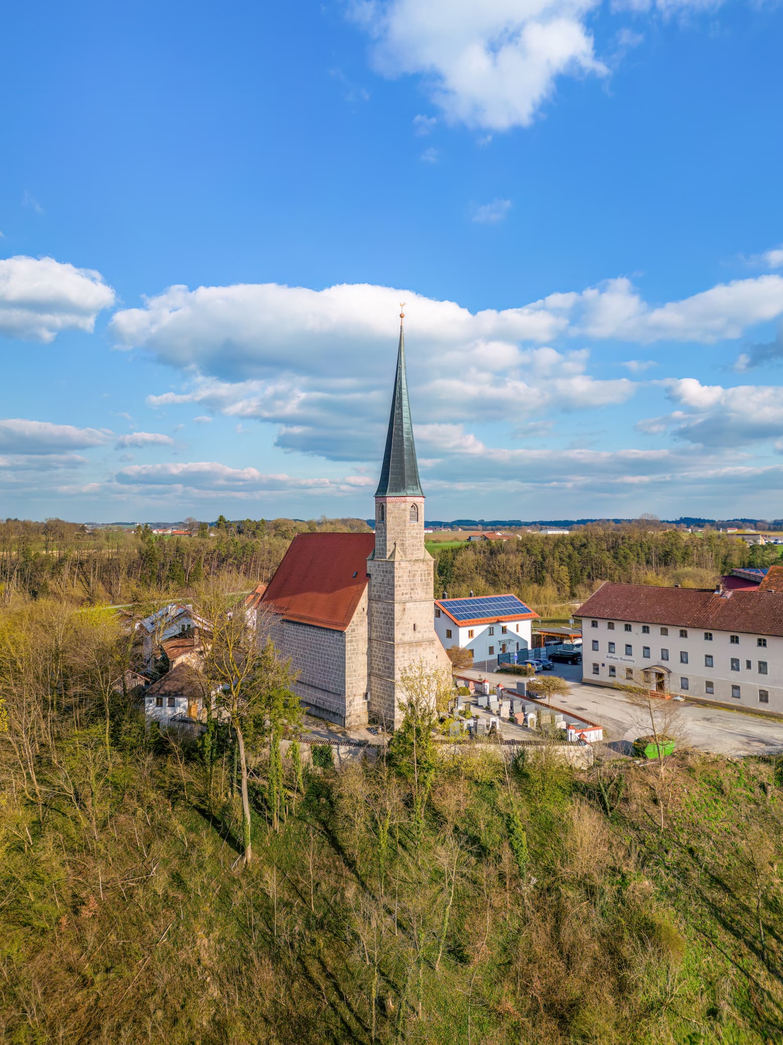 Luftaufnahme der Pfarrkirche St. Stephanus in Mauerberg, Garching, Landkreis Altötting, Oberbayern, Deutschland. Kirche auf Anhöhe in der Inn-Salzach Region.
