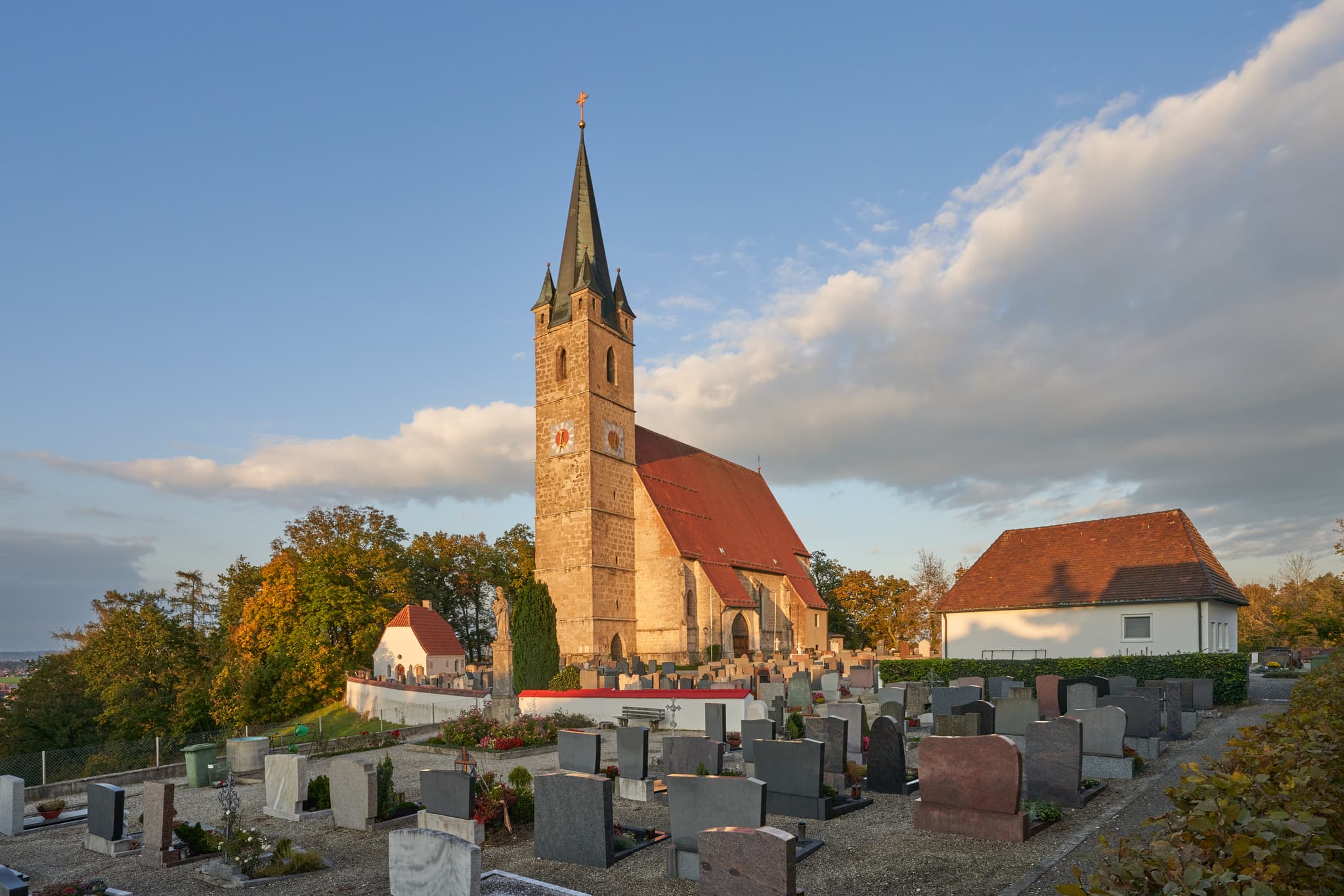 Pfarrkirche St. Rupertus, Burgkirchen am Wald, Tüssling, Altötting, Oberbayern. Kirche mit Friedhof auf Anhöhe, beleuchtet von Abendlicht.