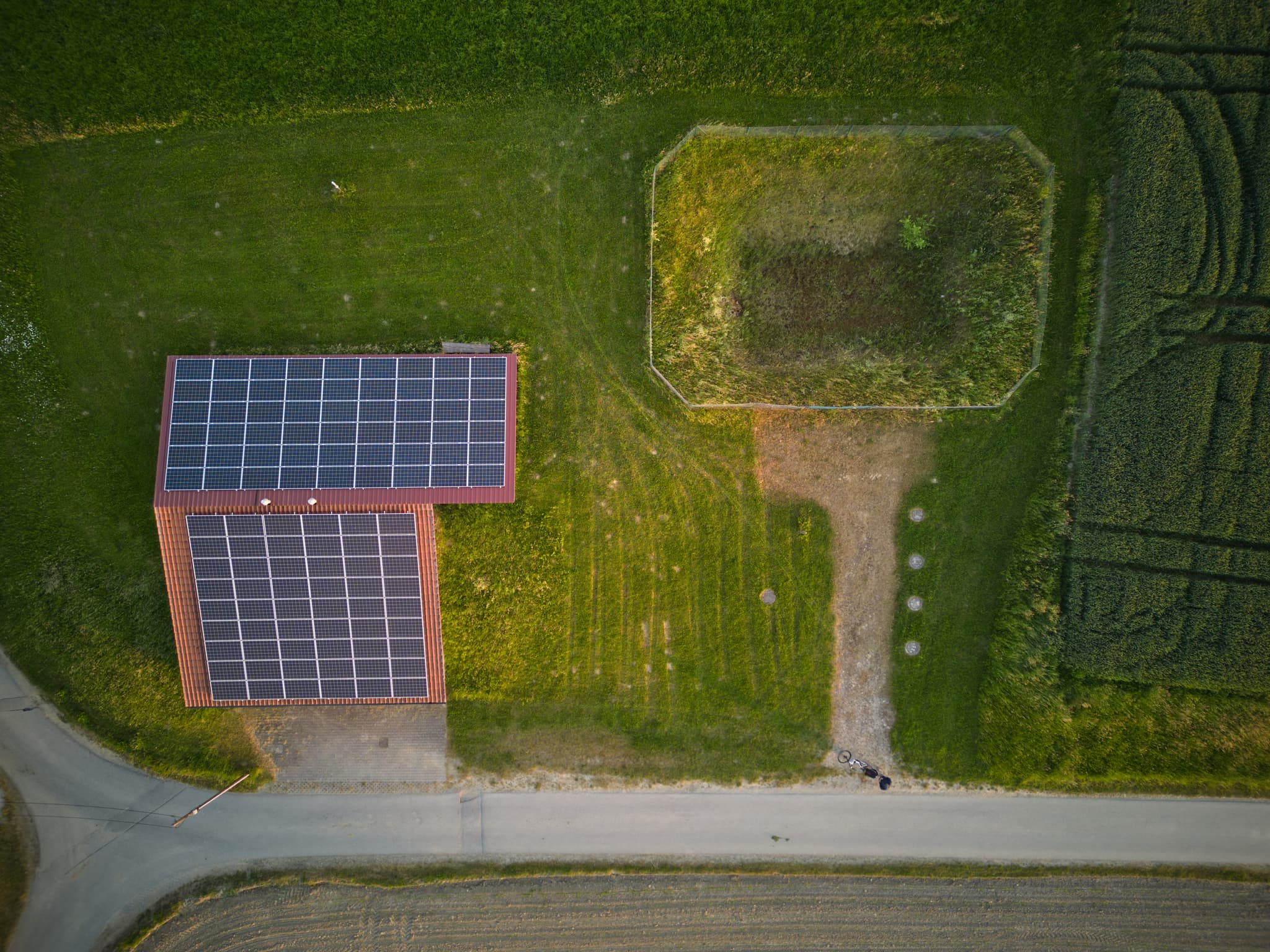 Luftbild eines Wasserspeichers und Gebäudes mit Solaranlage bei Hoheneck, Reischach. Gelegen im Landkreis Altötting, Oberbayern.