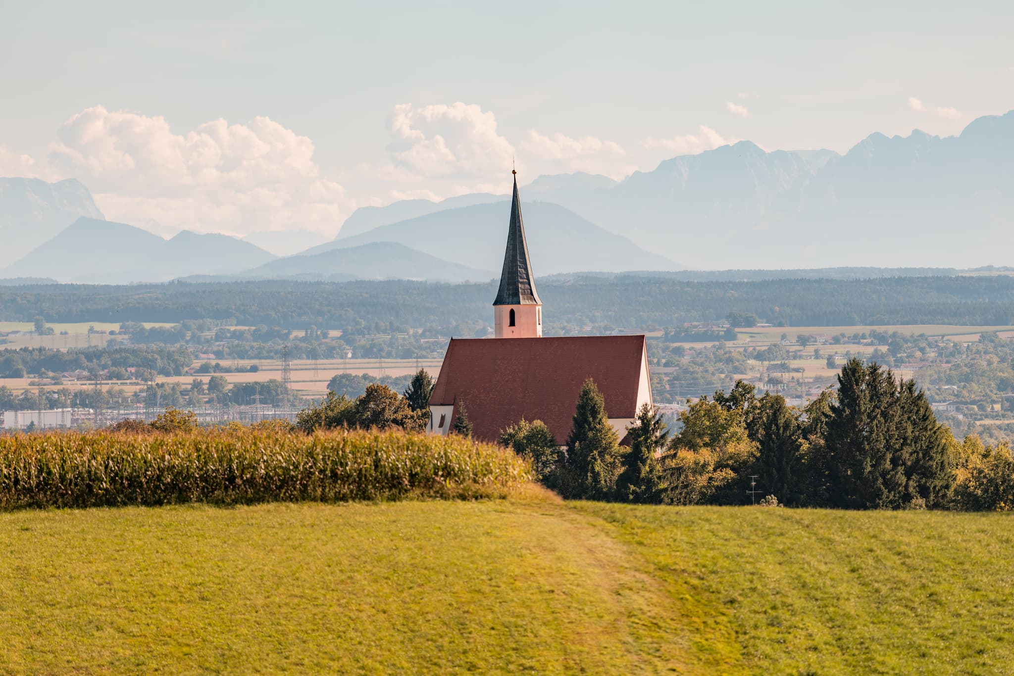 Pfarrkirche St. Georg und Urban in Stubenberg, Rottal-Inn, Niederbayern. Kirche mit weitem Alpenblick und Bergpanorama, Holzland, Deutschland.