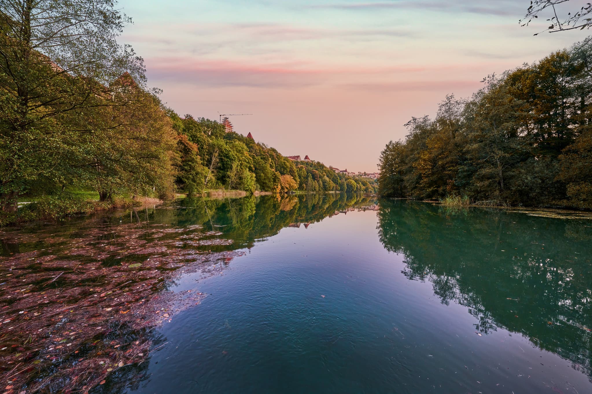Wöhrsee Burghausen, Altötting, Oberbayern, Inn-Salzach, Deutschland. Ruhige Wasseroberfläche, ufernahe Bäume und herbstliches Laub. Abendstimmung am See.