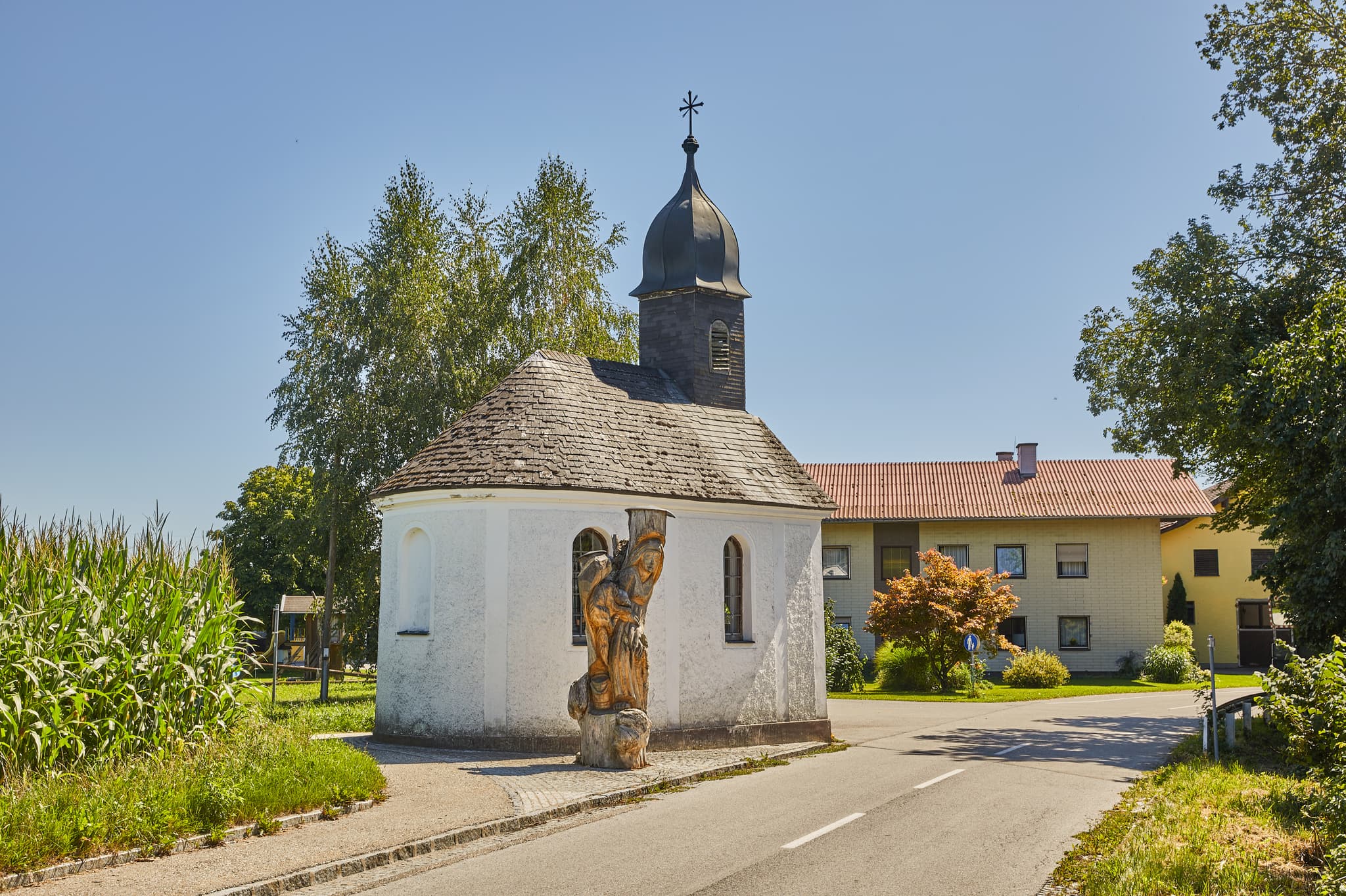 Kapelle in St. Radegund, Oberösterreich, im ländlichen Innviertel. Das Gotteshaus steht umgeben von Bäumen und Maisfeldern im Bezirk Braunau am Inn, Österreich.