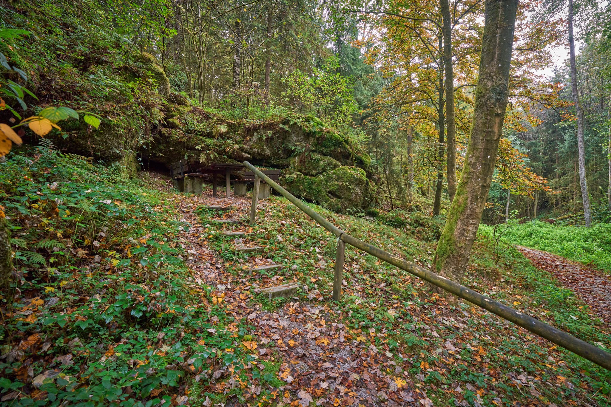 Picknicktisch und Bänke vor felsiger Felsformation im Wald. Bad Griesbach, Landkreis Passau, Niederbayern, Bayerischer Wald, Deutschland.